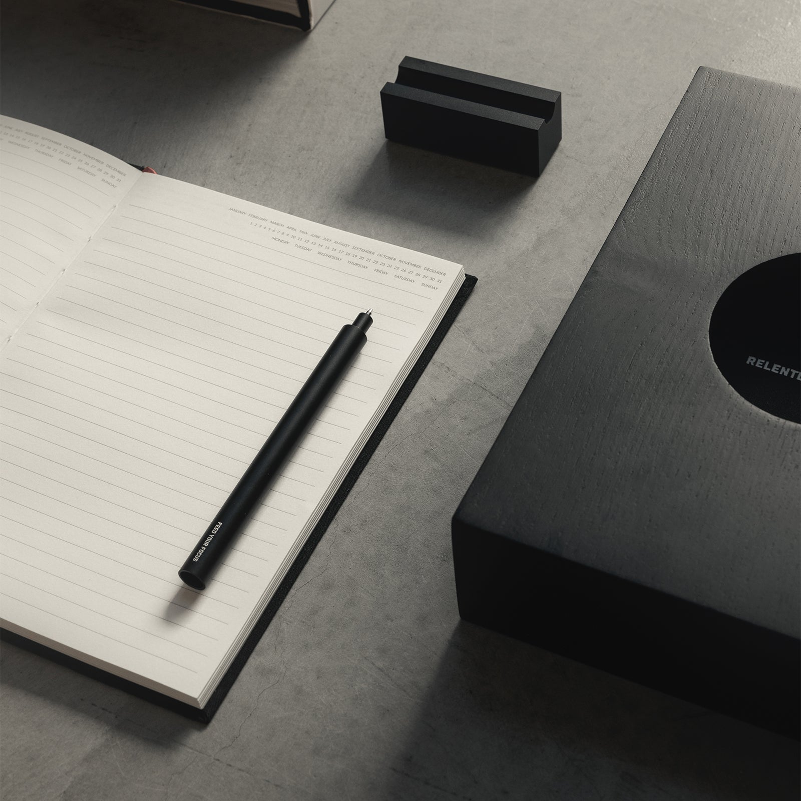 flatlay ASRV x Walden Magnetic Pen & Stand in black, overhead view with notebook