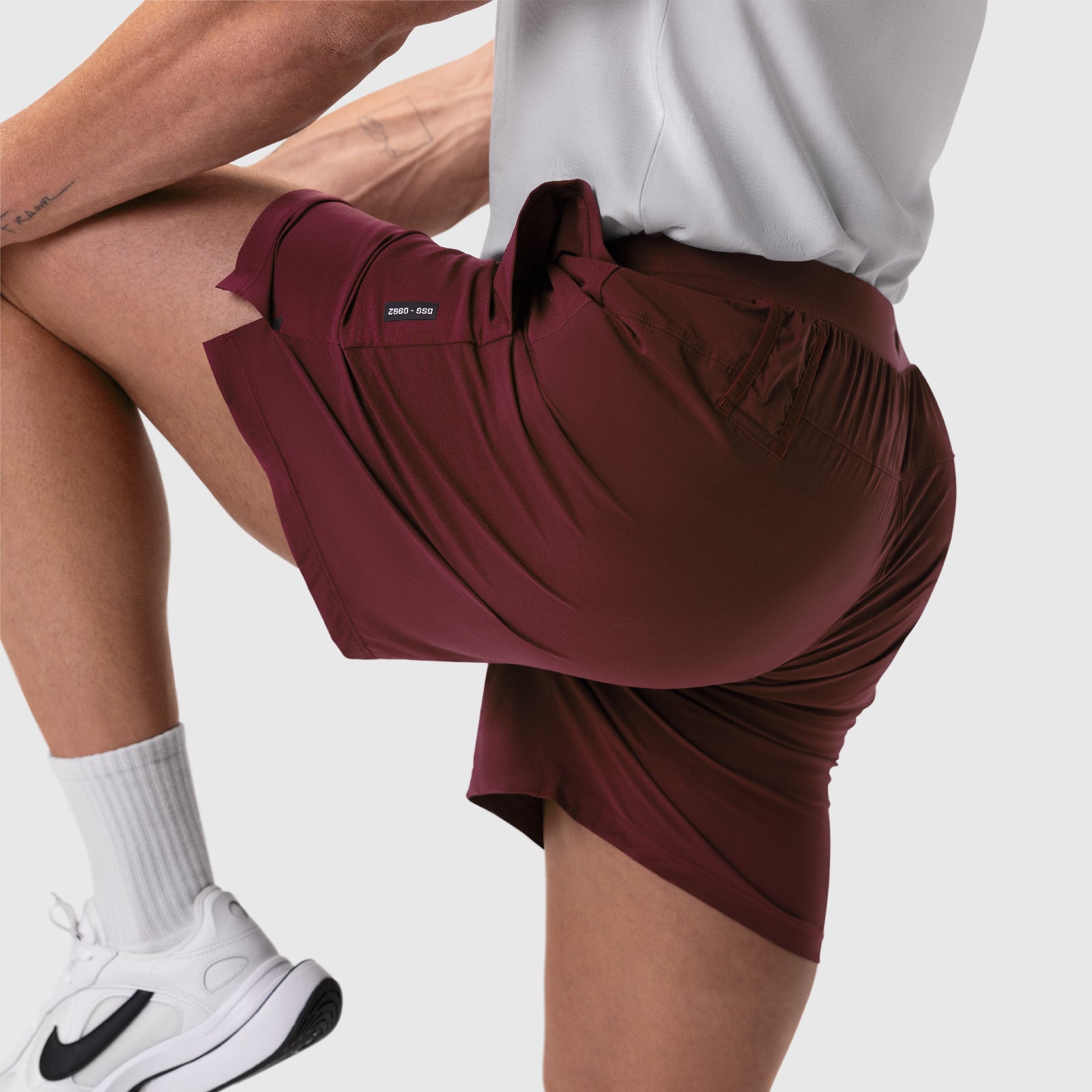 Aerotex Training Short in crimson worn by model, side view during stretch pose