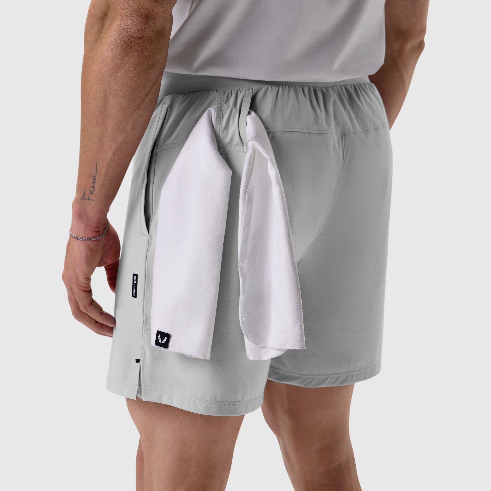 Aerotex Training Short in slate grey worn by model, back view with white towel