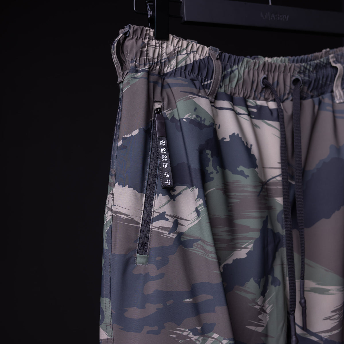WN'20 Cargo High Rib Jogger in camouflage print, detail shot of drawstring and zipper