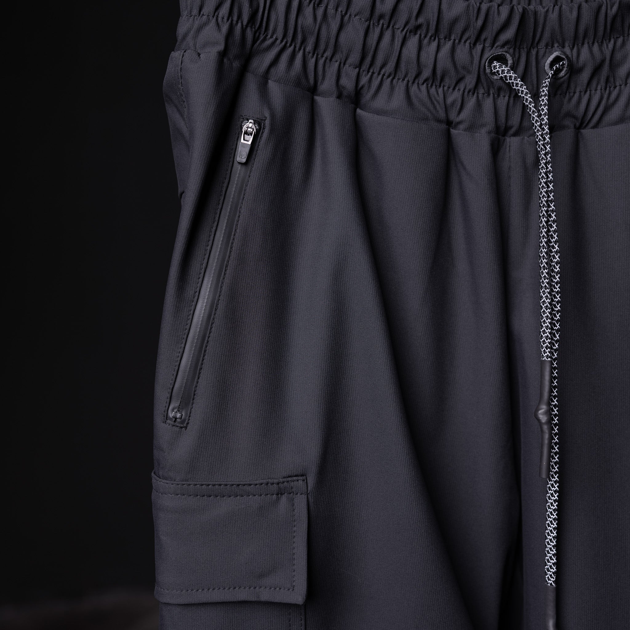 SP'20 Cargo Track Pant in black, detail shot of side pocket and drawstring