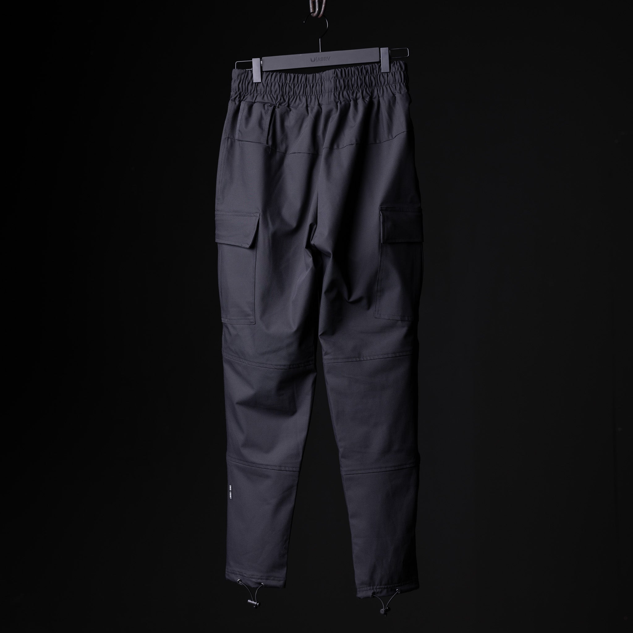 SP'20 Cargo Track Pant in charcoal gray, displayed on hanger against black background