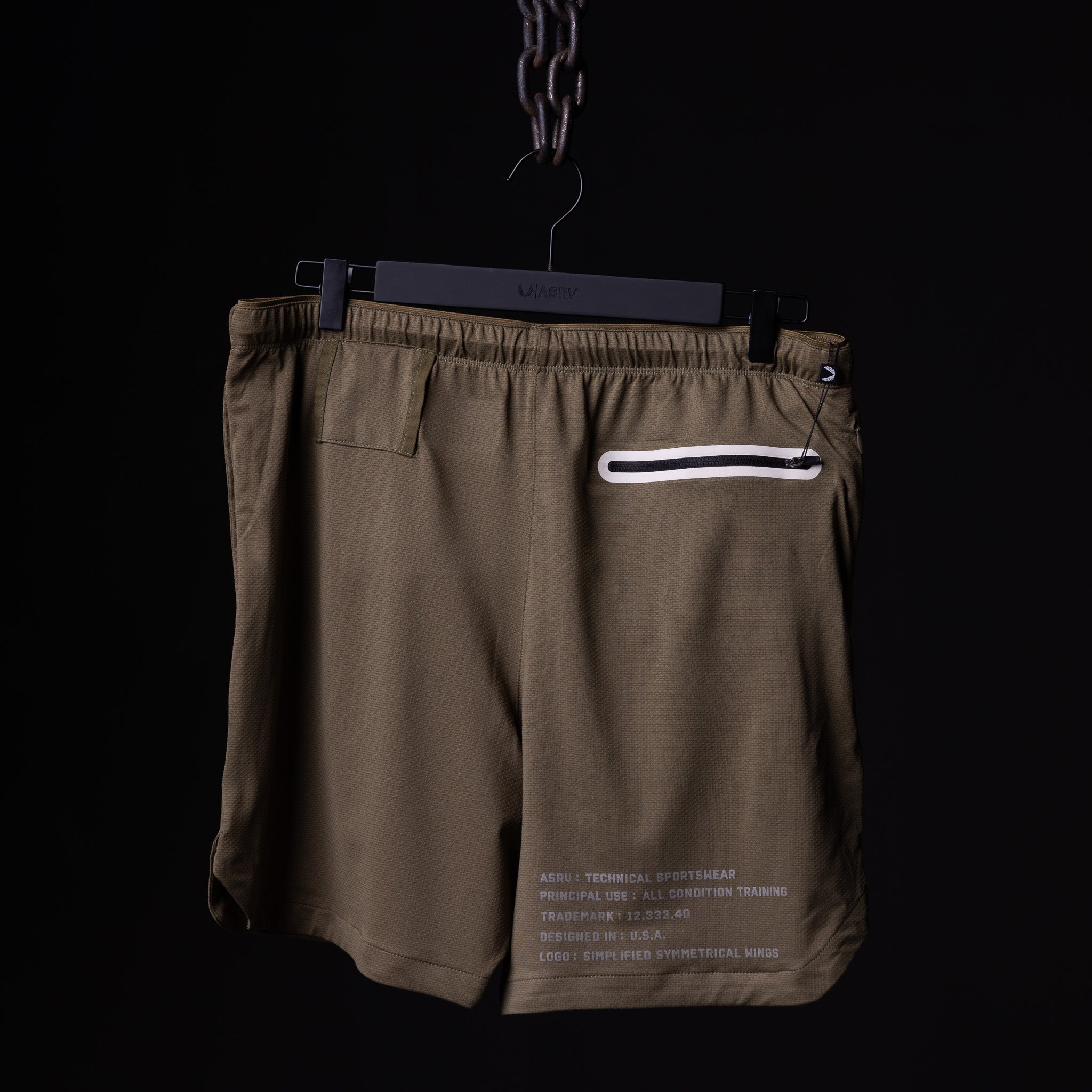 SP'19 7" Linerless Short in khaki, displayed on hanger against black background
