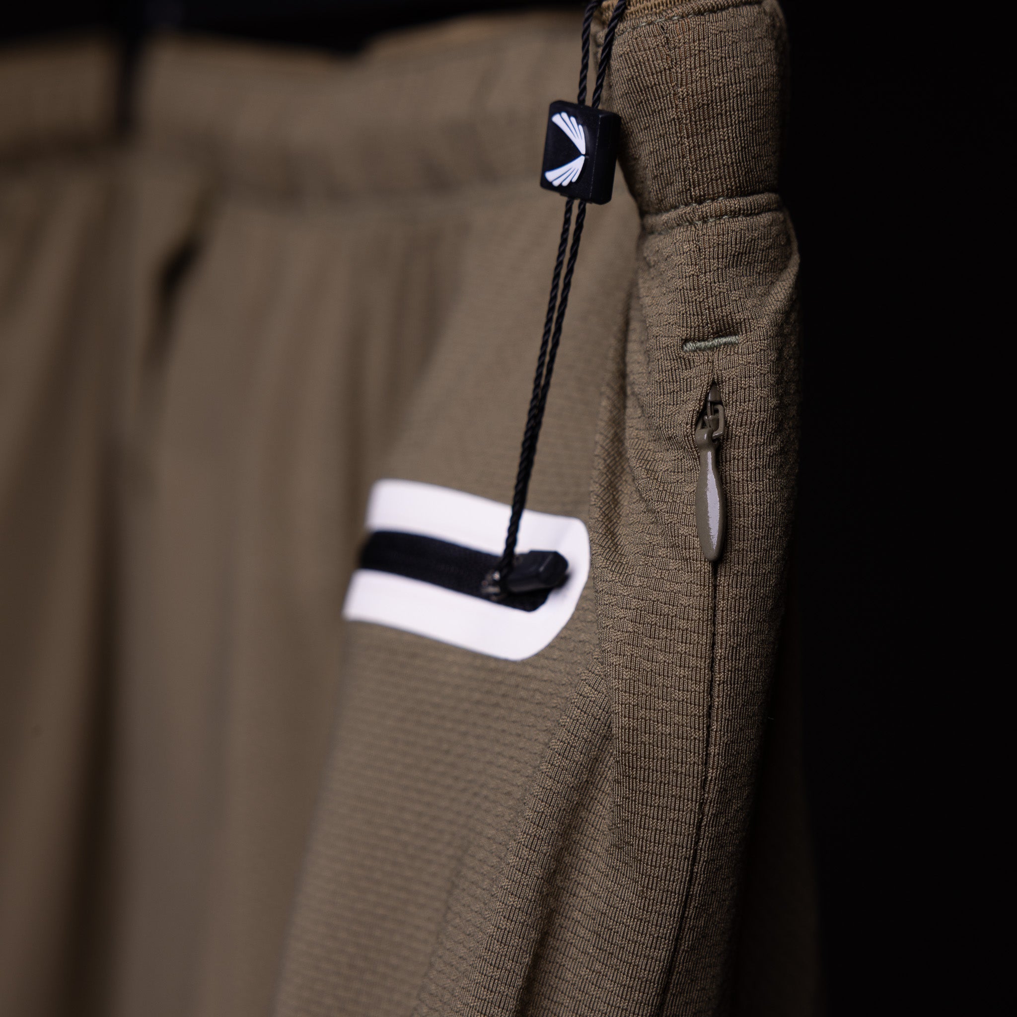 SP'19 7" Linerless Short in khaki, detail shot of drawcord and pocket