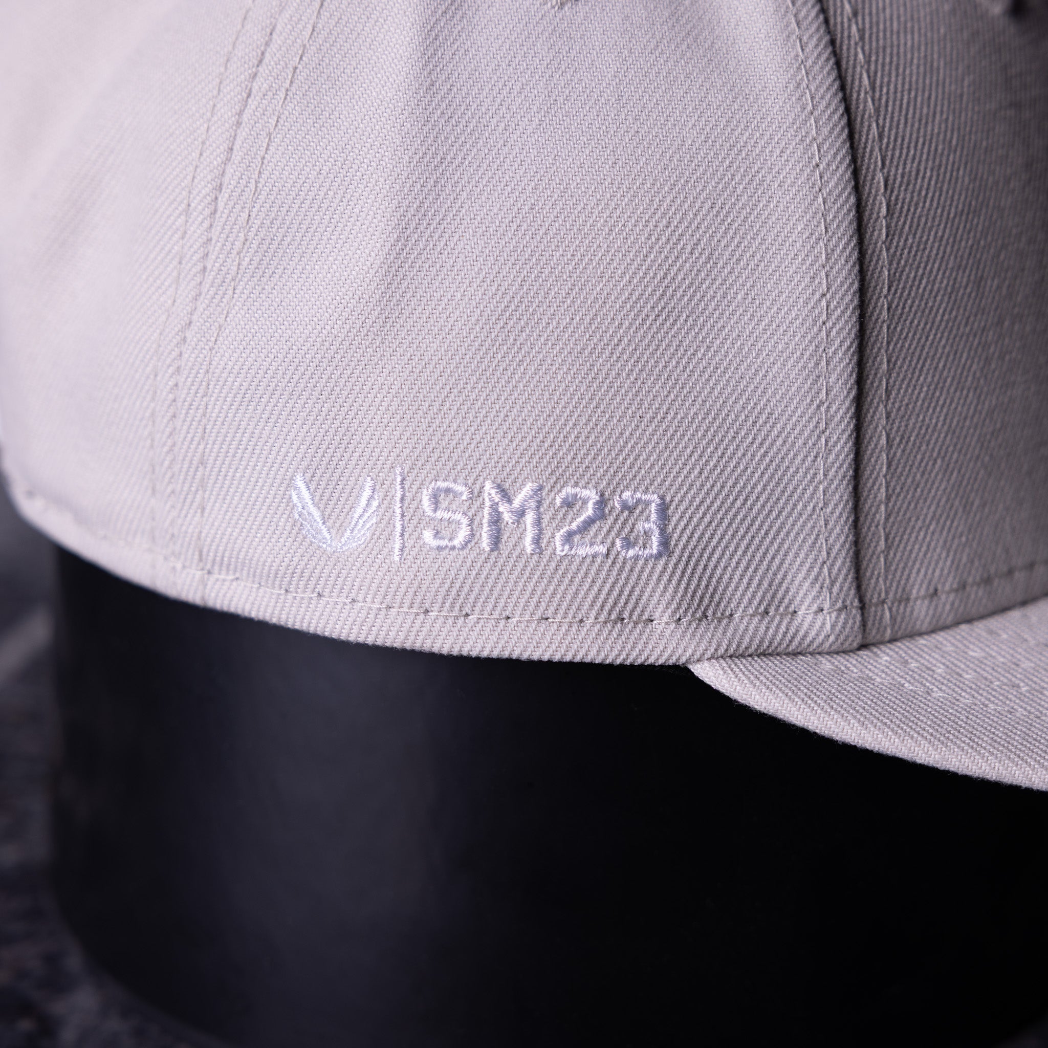 SM'23 Valley of Fire Low Pro Hat in grey, closeup detail of embroidered logo on brim