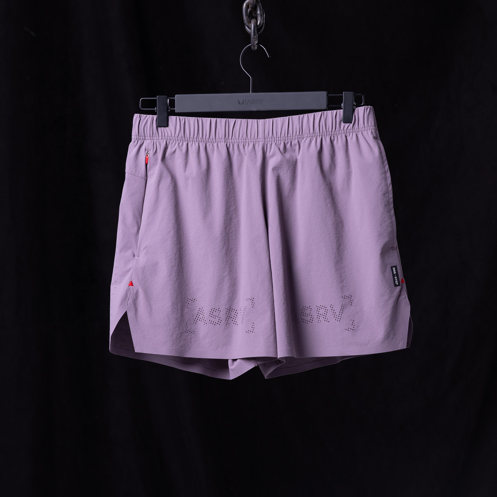 Flatlay of WN'23 6" Perforated Short in lavender purple, hung on hanger