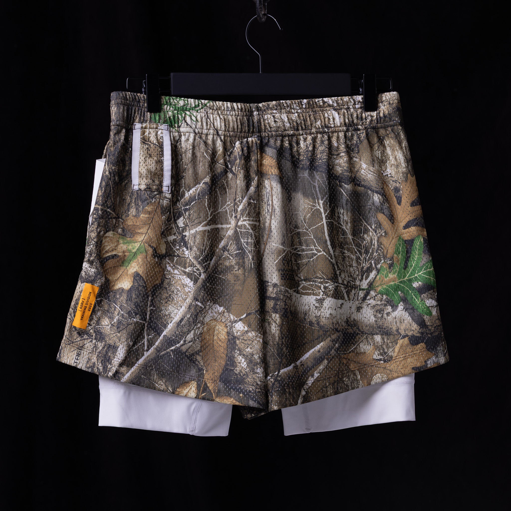 flatlay Training Division Mesh Shorts in camouflage with white underlay, front view