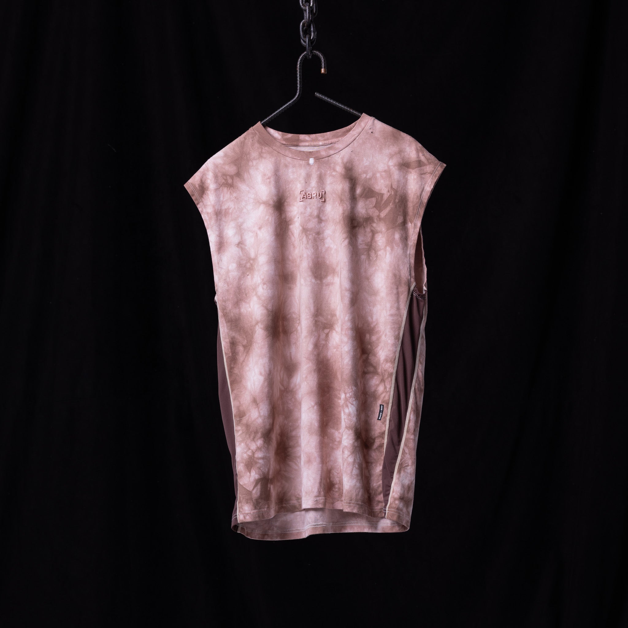 Pink tie dye cutoff tank on hanger against black background, front view