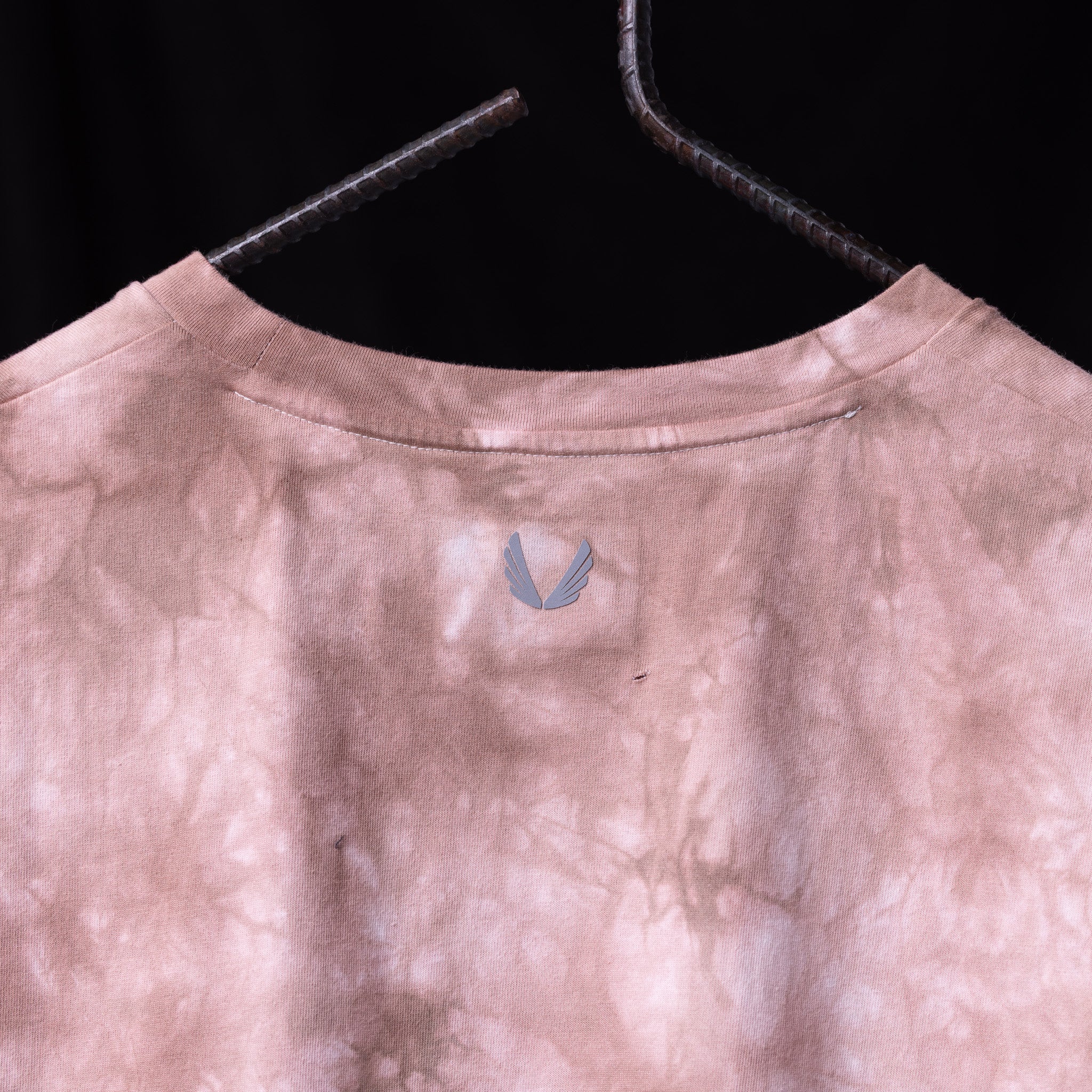 2020 Tie Dye Cutoff Tank in mauve pink, hanging on wooden hanger back view
