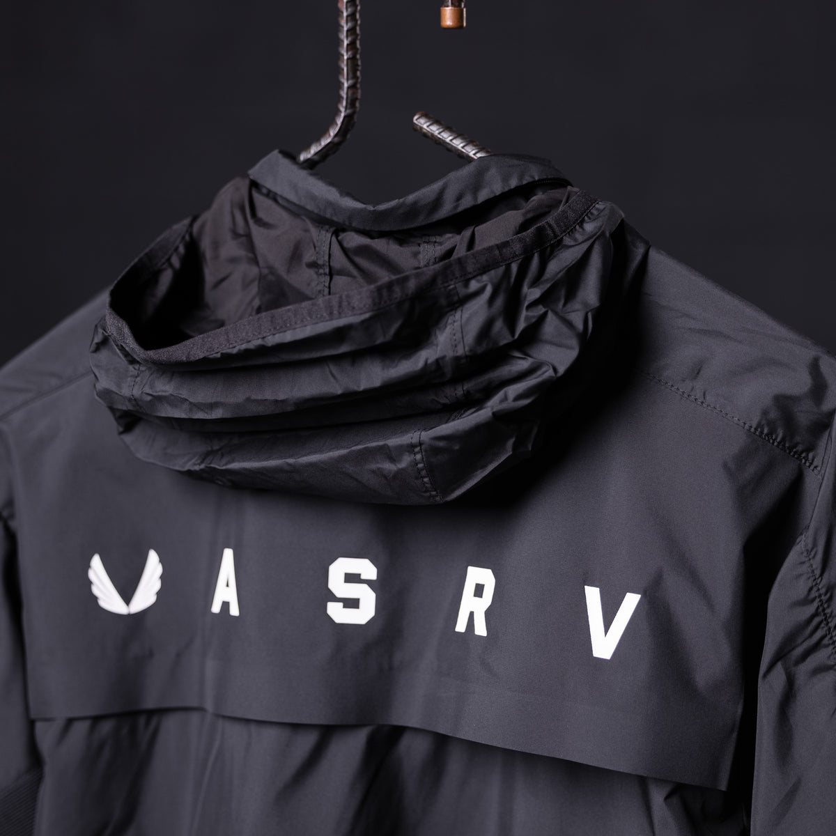 SP'23 Waterproof Jacket in black on hanger, front view with hood up