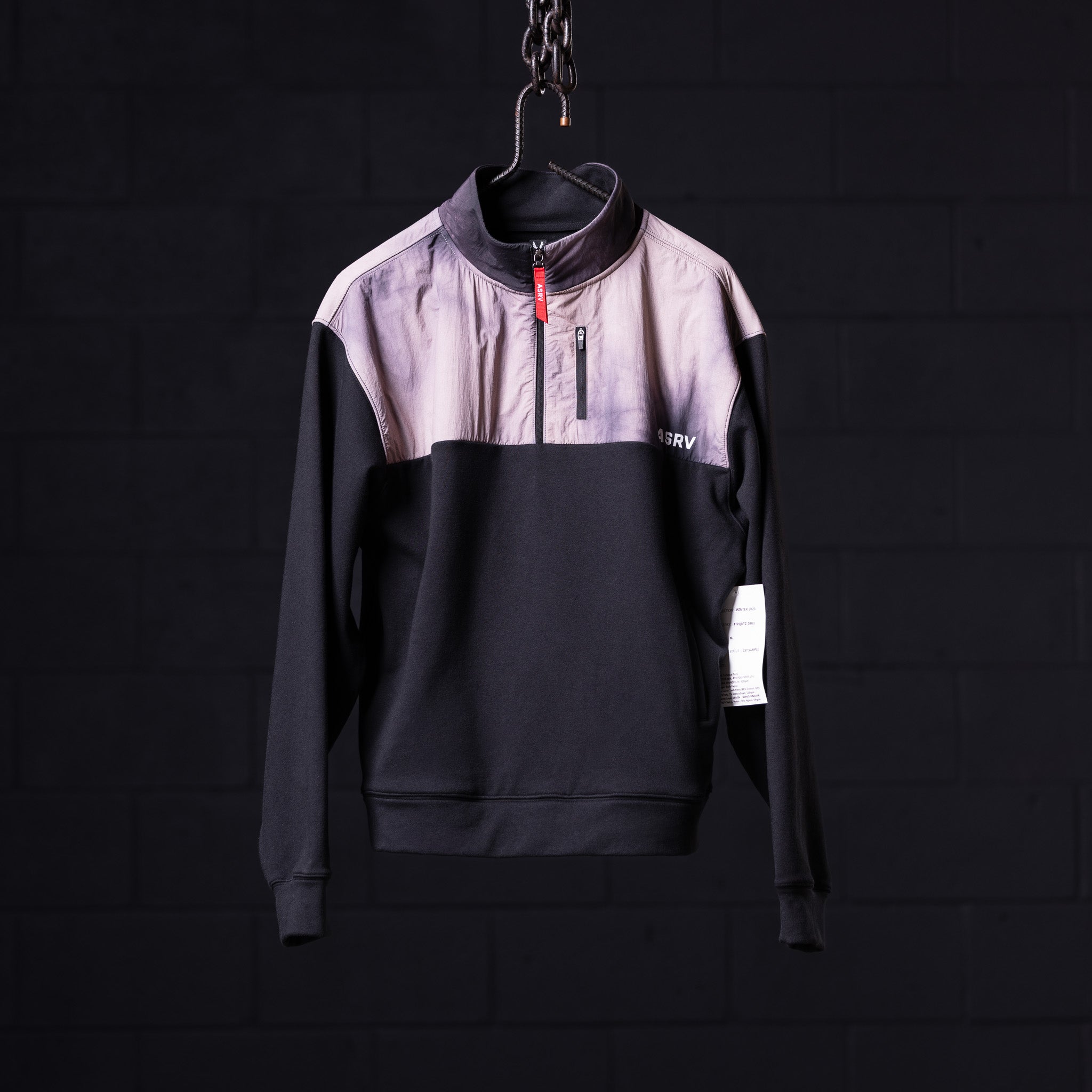 WN'23 Panel Quarter Zip Jacket in black and lavender, displayed on hanger against dark background
