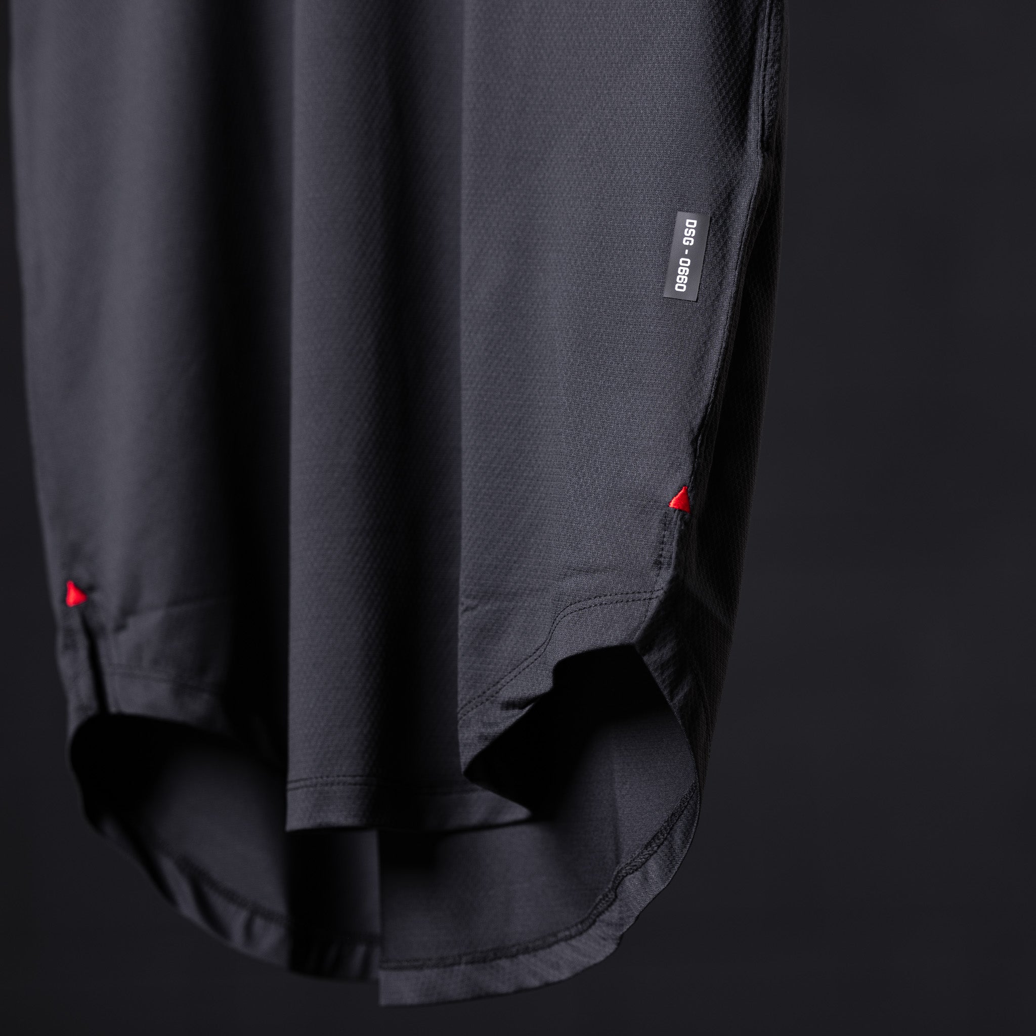SM'22 Established Tee in charcoal, detail shot of hem and side seam with red accent