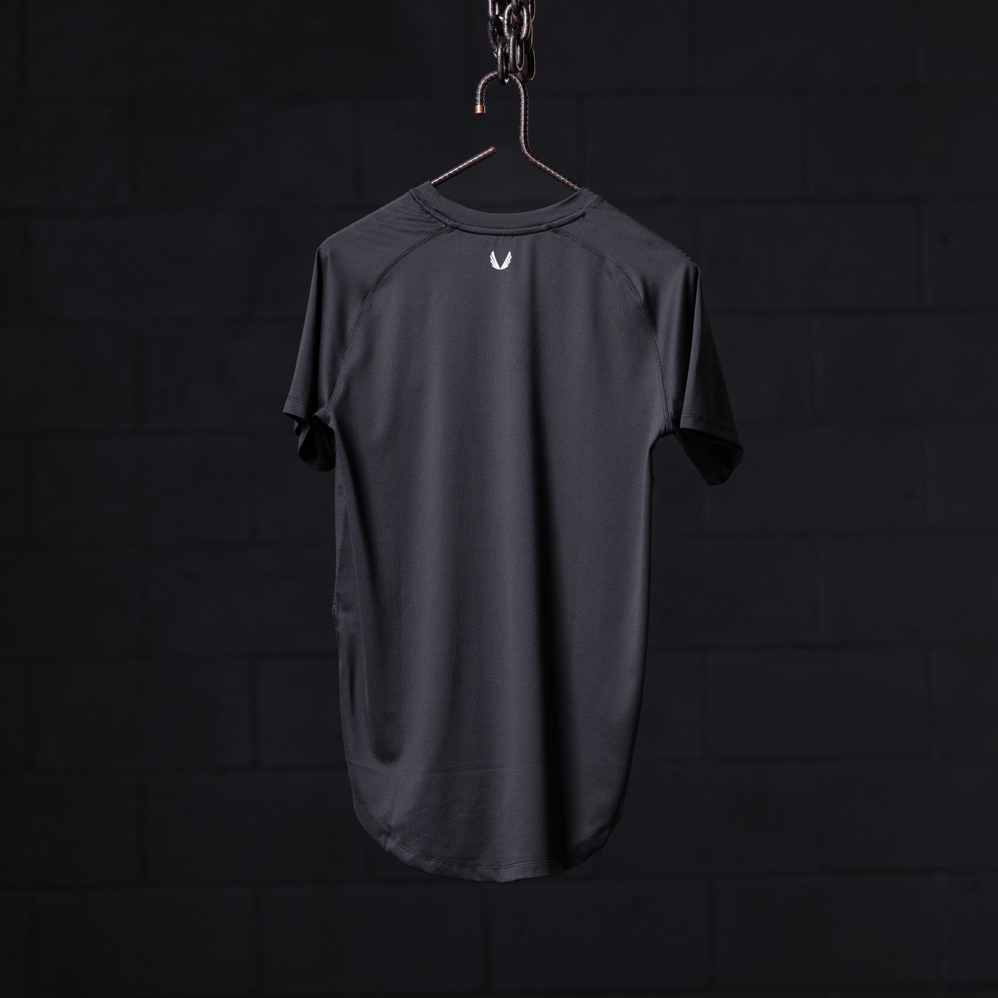 SM'22 Established Tee in charcoal gray, displayed on hanger against dark background, back view