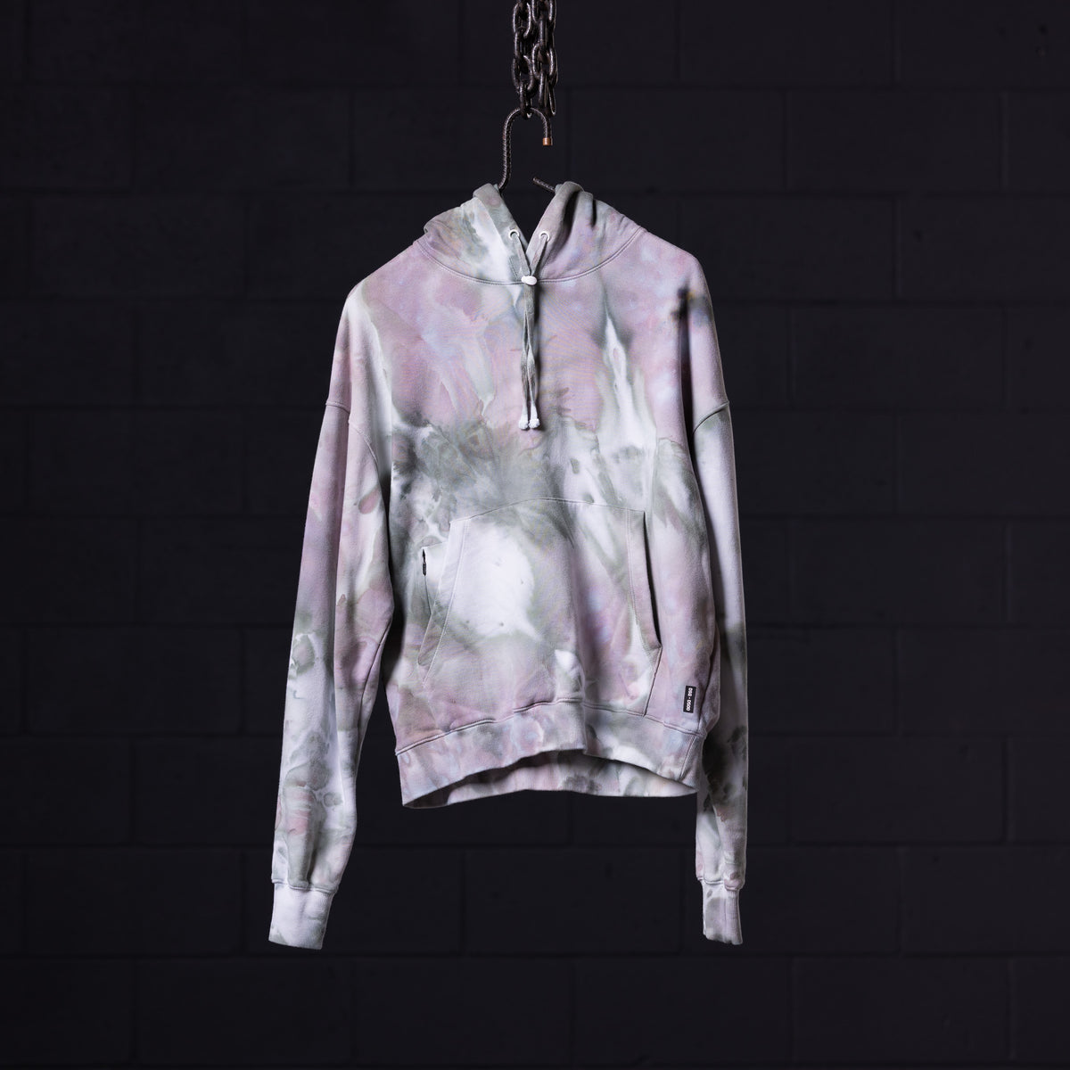SM'22 Tie Dye Hoodie in pink and white tie dye, displayed on hanger against dark background