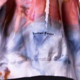 SM'22 Tie Dye Hoodie in pink and blue tie dye, worn by model showing front chest detail