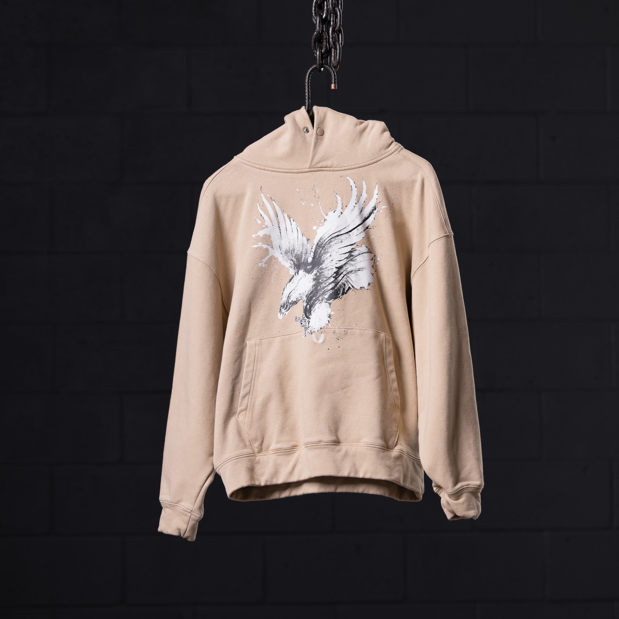 FA'23 Graphic Hoodie in beige, displayed on hanger with white eagle illustration on back