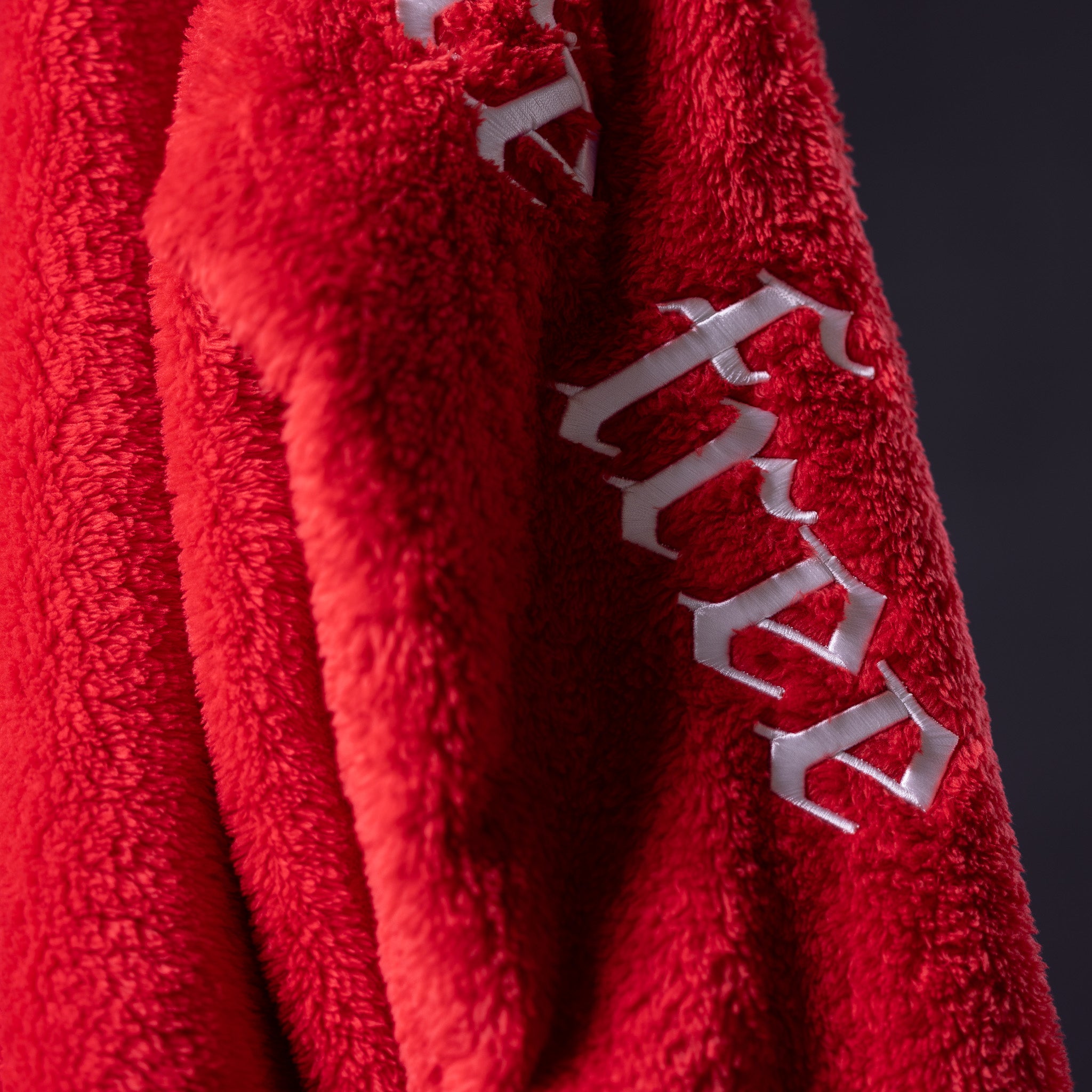 WN '23 Sherpa Recovery Hoodie in red with white stitching detail, close-up of fabric and seam