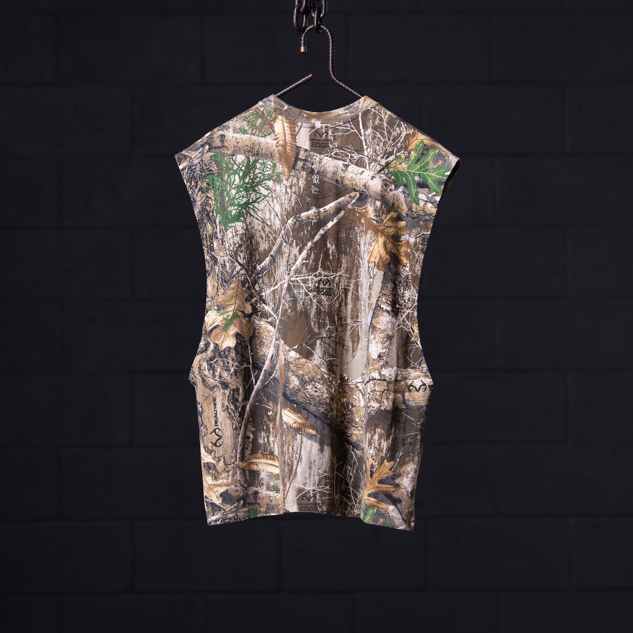 FA'23 Rocker Cutoff sleeveless shirt in camouflage print, displayed on hanger against dark background