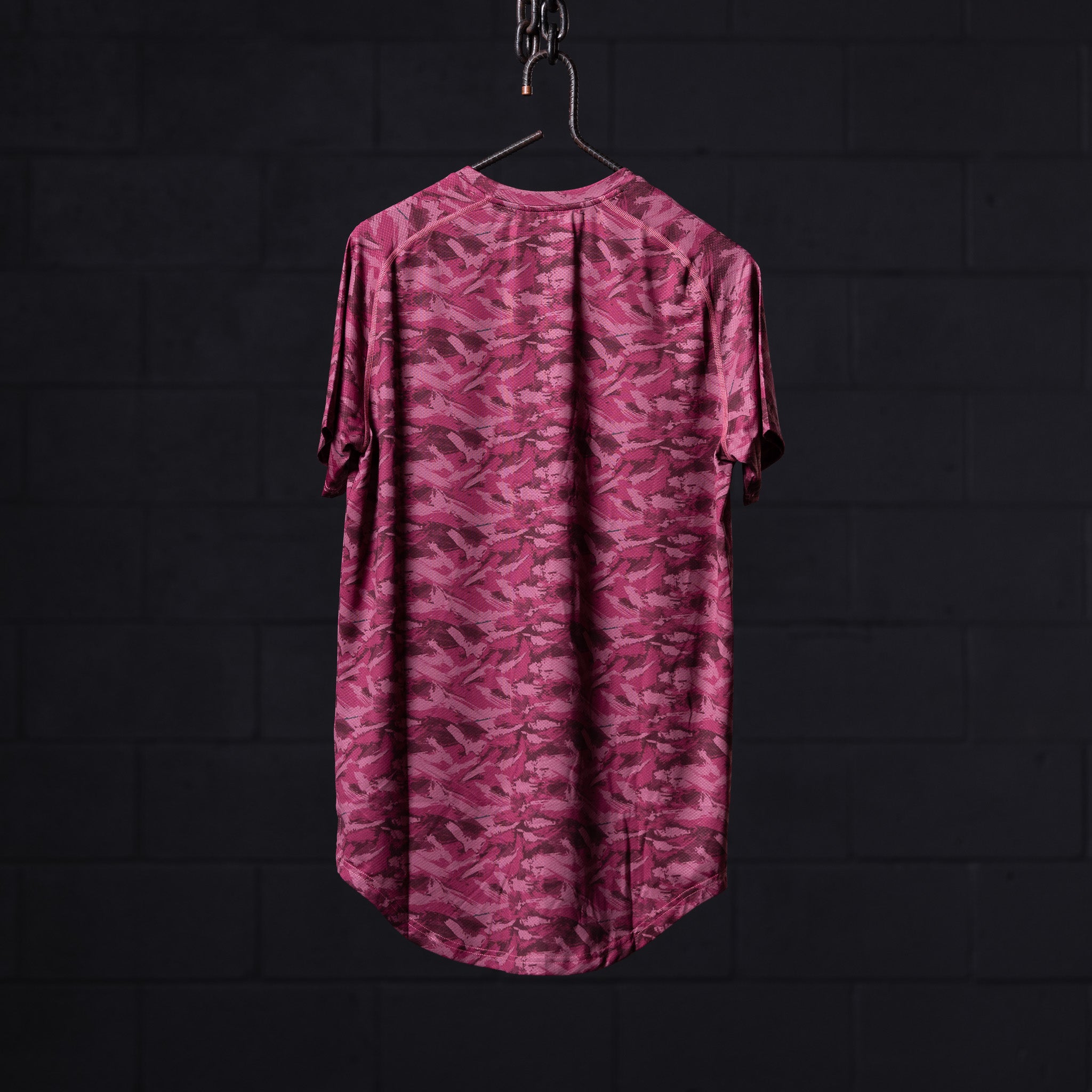 flatlay SM'20 Established Tee in pink camo, back view on hanger against dark background