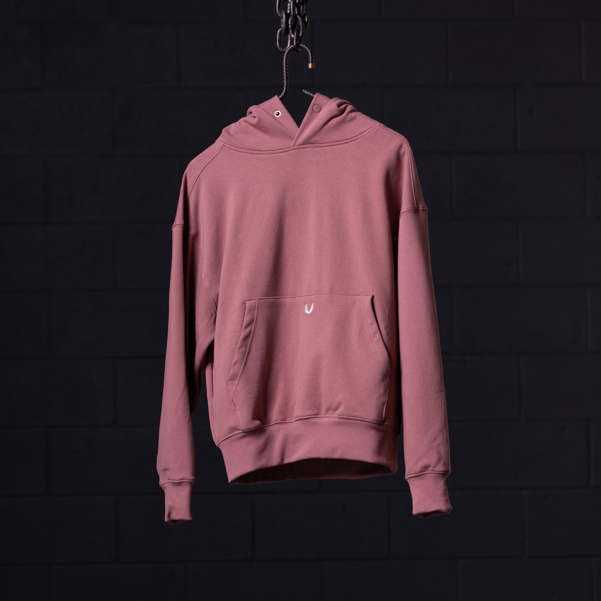 Pink Tech Terry Eagle Hoodie displayed on hanger against dark background, back view