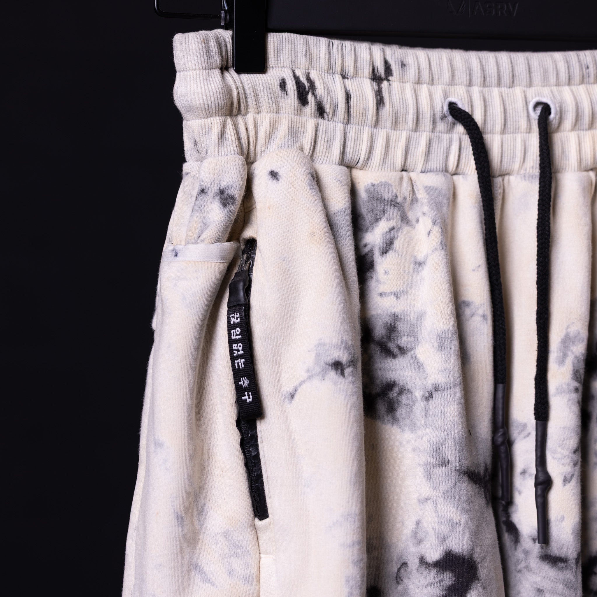Tie dye sweat shorts in cream and gray, detail shot of drawstring and waistband