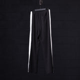 SM'24 Waffle Knit Sweat Pant in black with white side stripes, hanging on hanger