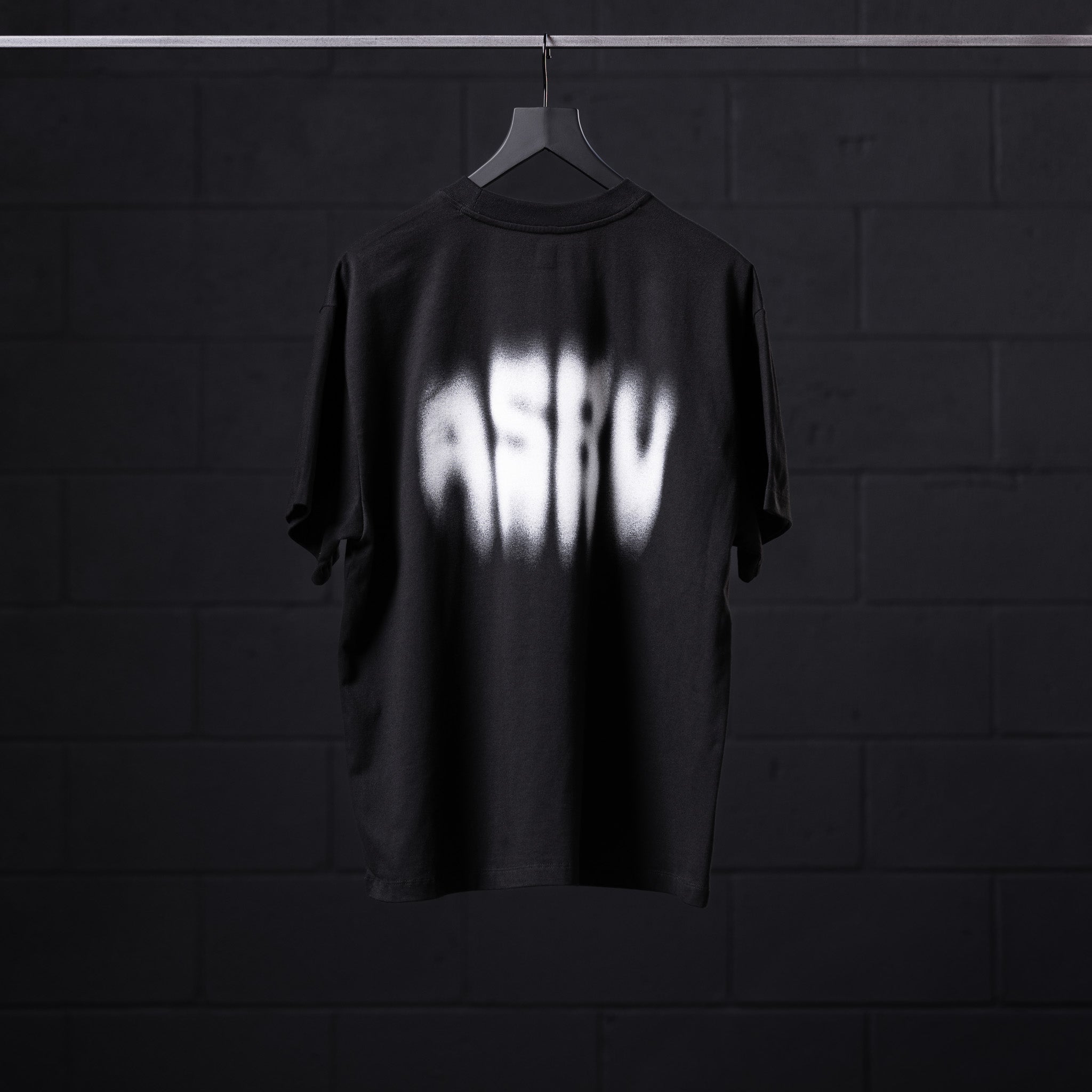 Black Tech Essential Relaxed Tee with Motion Blur design on hanger, back view