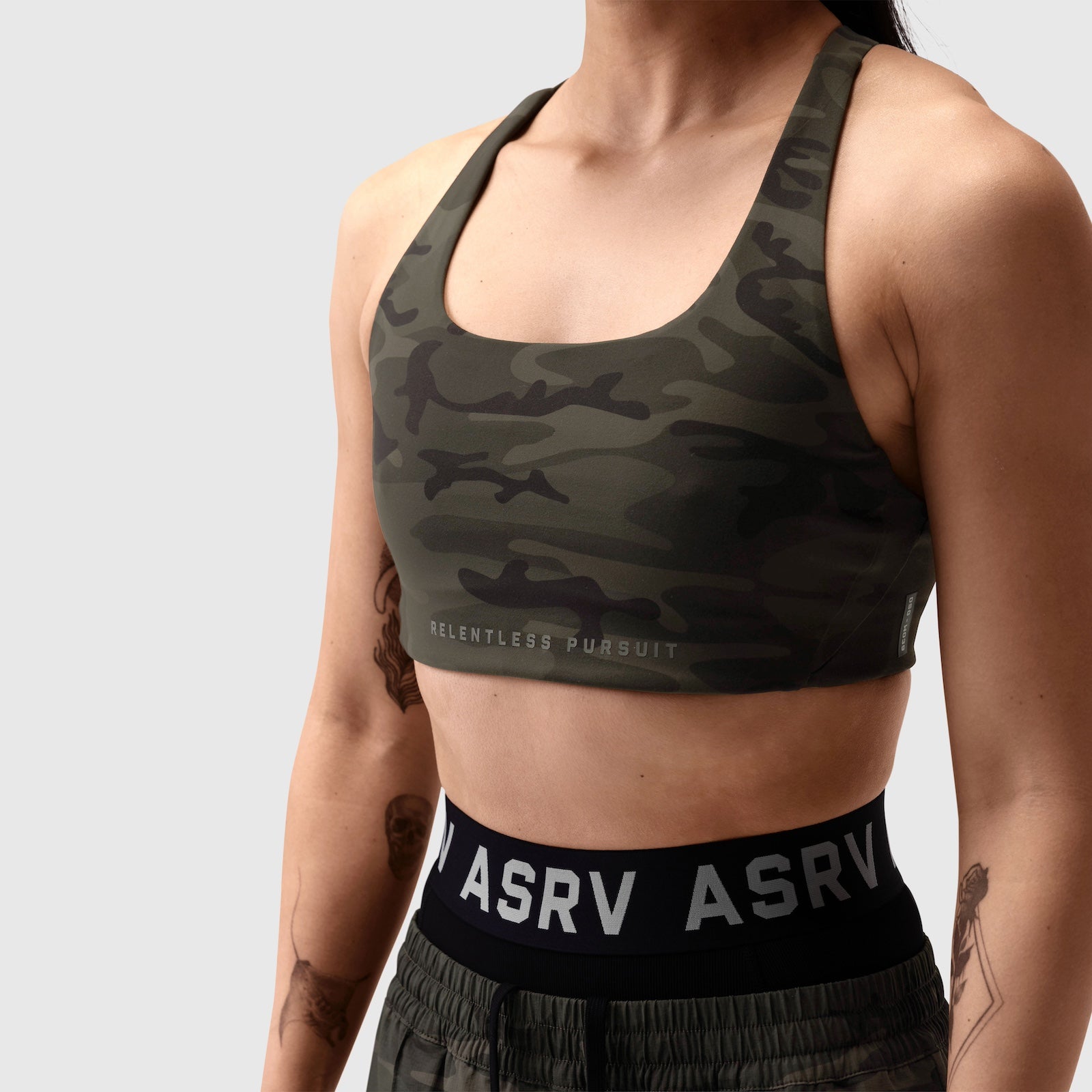 LYCRA® Hybrid Sports Bra in dark camo, modeled from front with waistband visible
