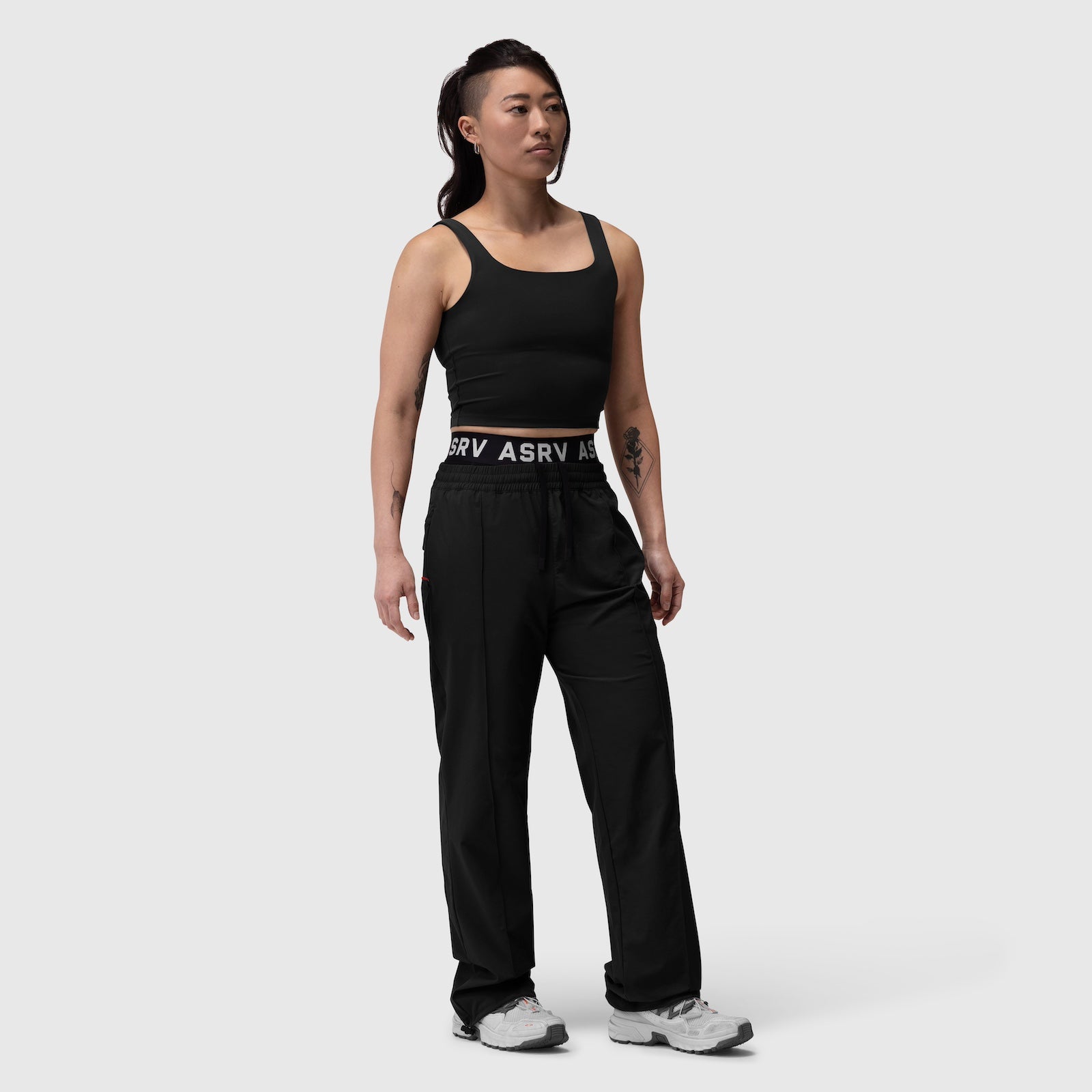 W036 Ripstop Relaxed Track Pant in black, worn with black tank top, front standing view
