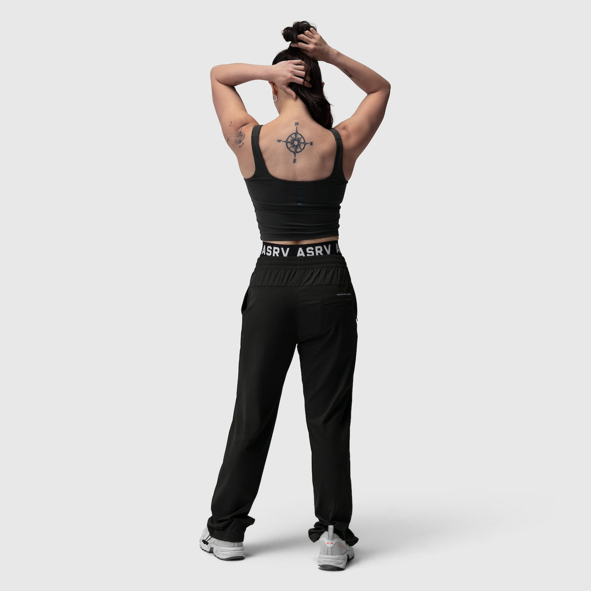 Black LYCRA® 2-in-1 tank top worn by model from back, showing compass tattoo