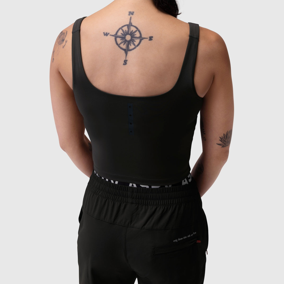 Black LYCRA® 2-in-1 tank top worn by model, back view showing compass tattoo