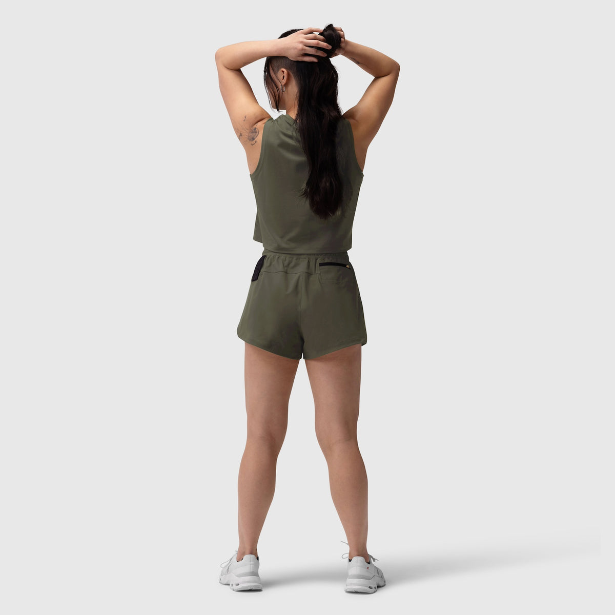 Tetra-Lite Linerless Short in olive, worn by model from back view with hands behind head