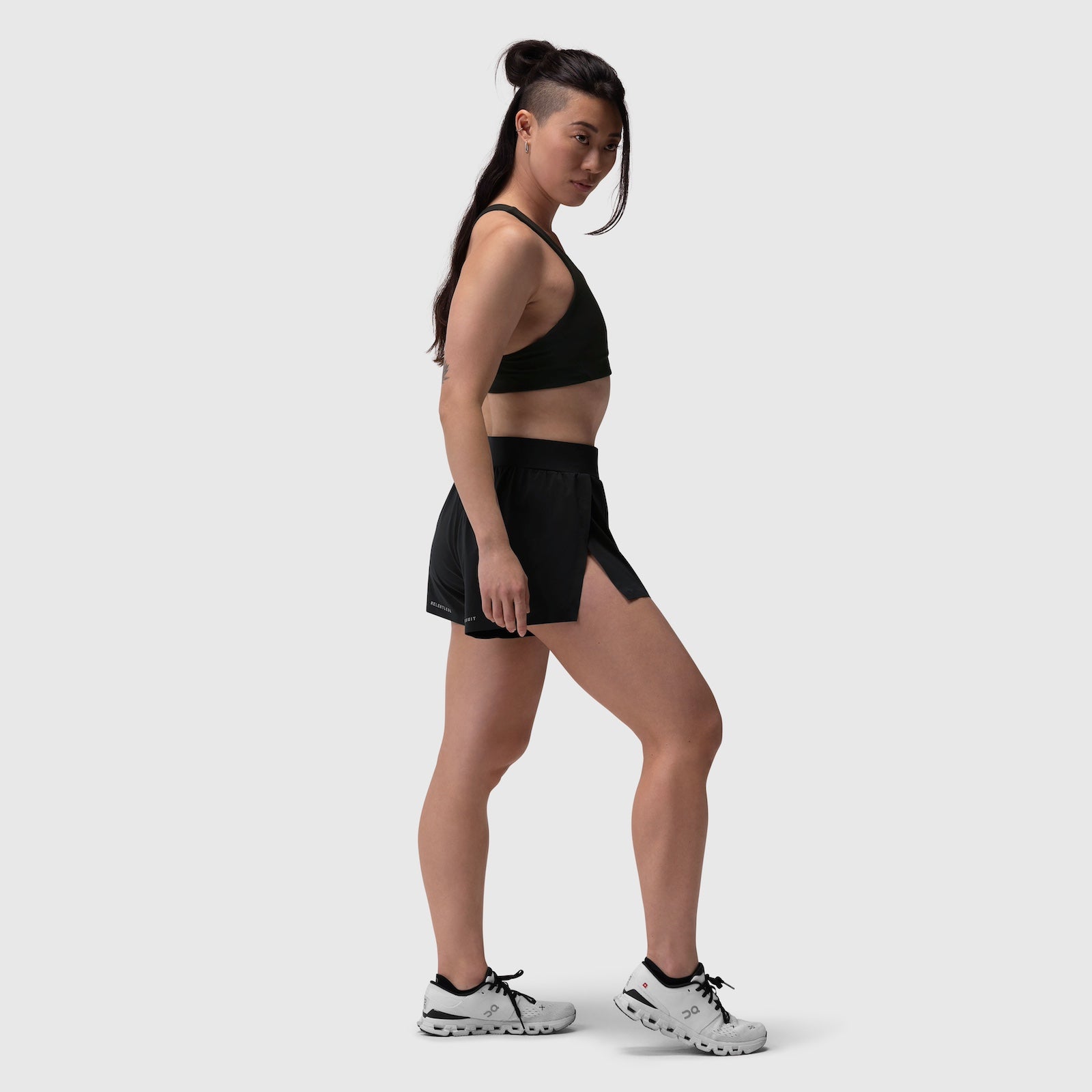 Aerotex Side Split Run Short in black, worn by model in side profile stance