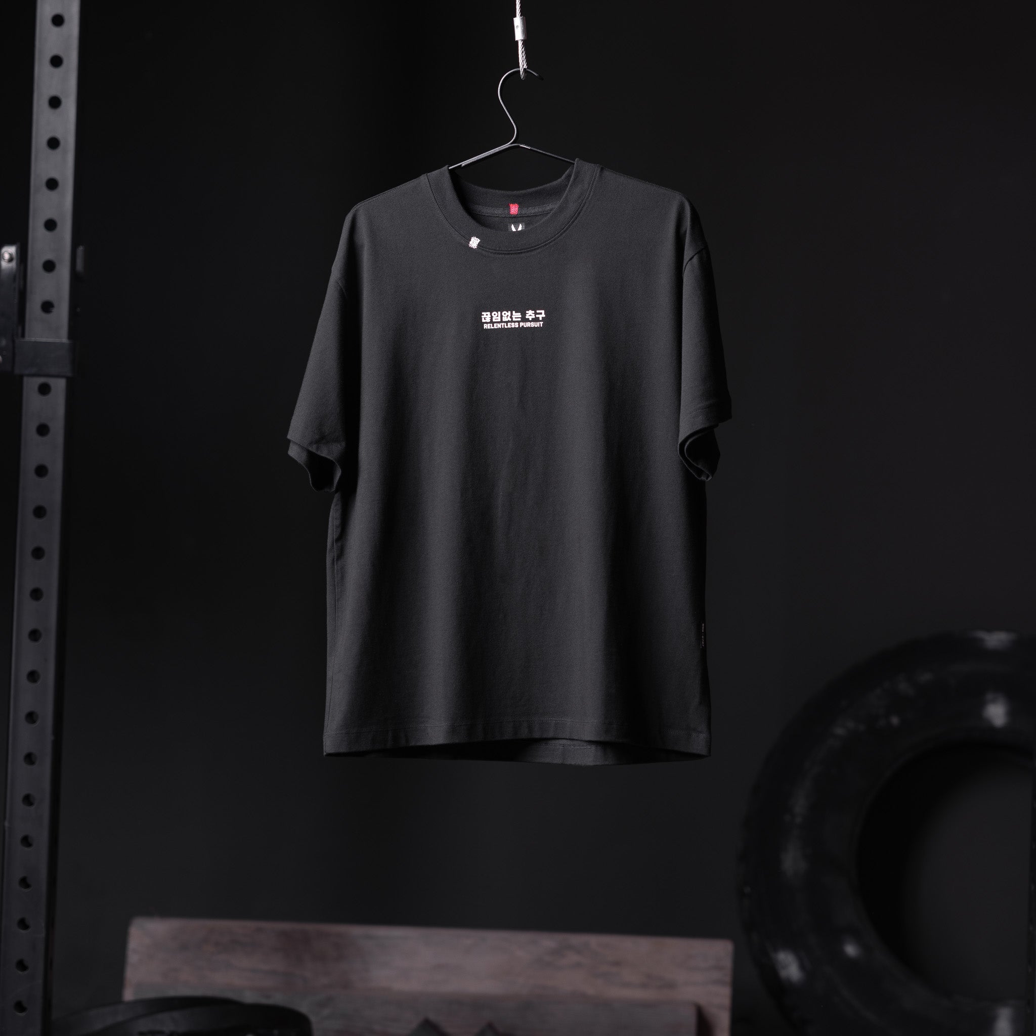 Tech Essential Relaxed Tee in black with RP Wings Stack graphic, displayed on hanger