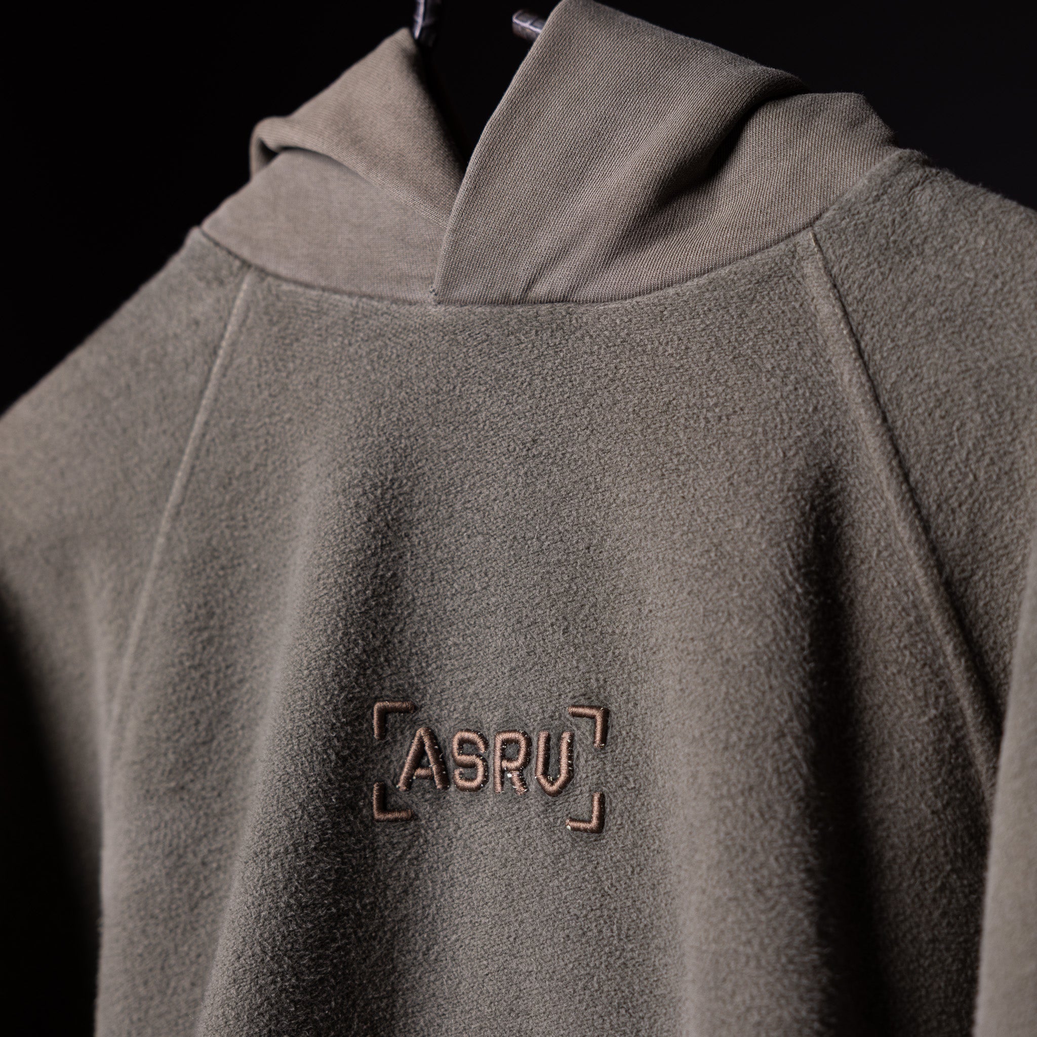 SS'20 Reverse Weave Hoodie in gray worn by model, front detail view showing ASRU logo