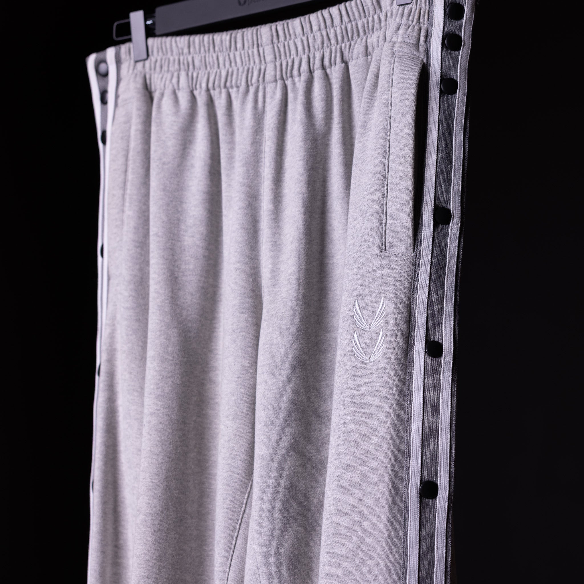SP'22 Tearaway Jogger in gray, displayed on hanger against dark background