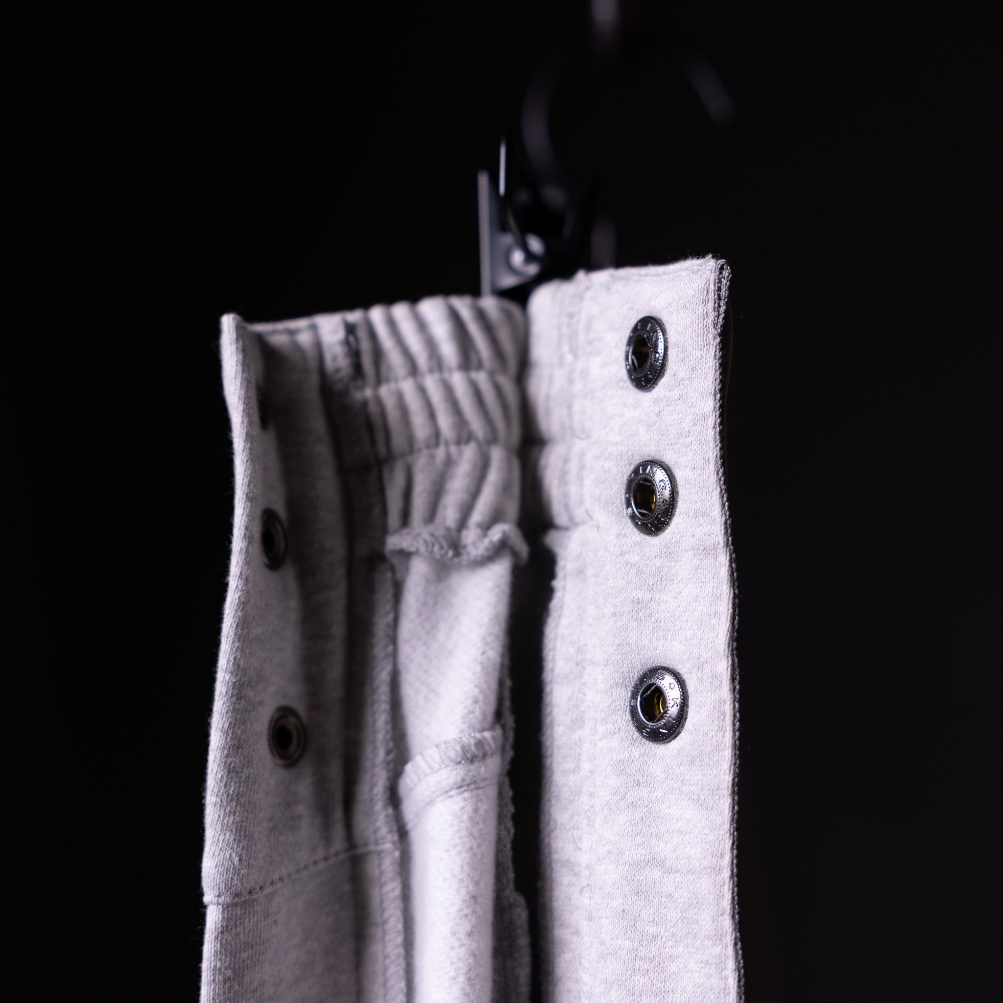 SP'22 Tearaway Jogger in white with metal eyelets, detail shot showing fabric texture and closures