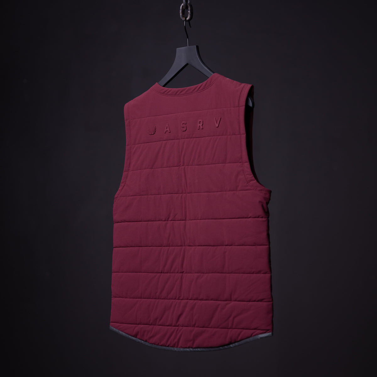 FA'22 Adventure Vest in burgundy displayed on hanger against dark background