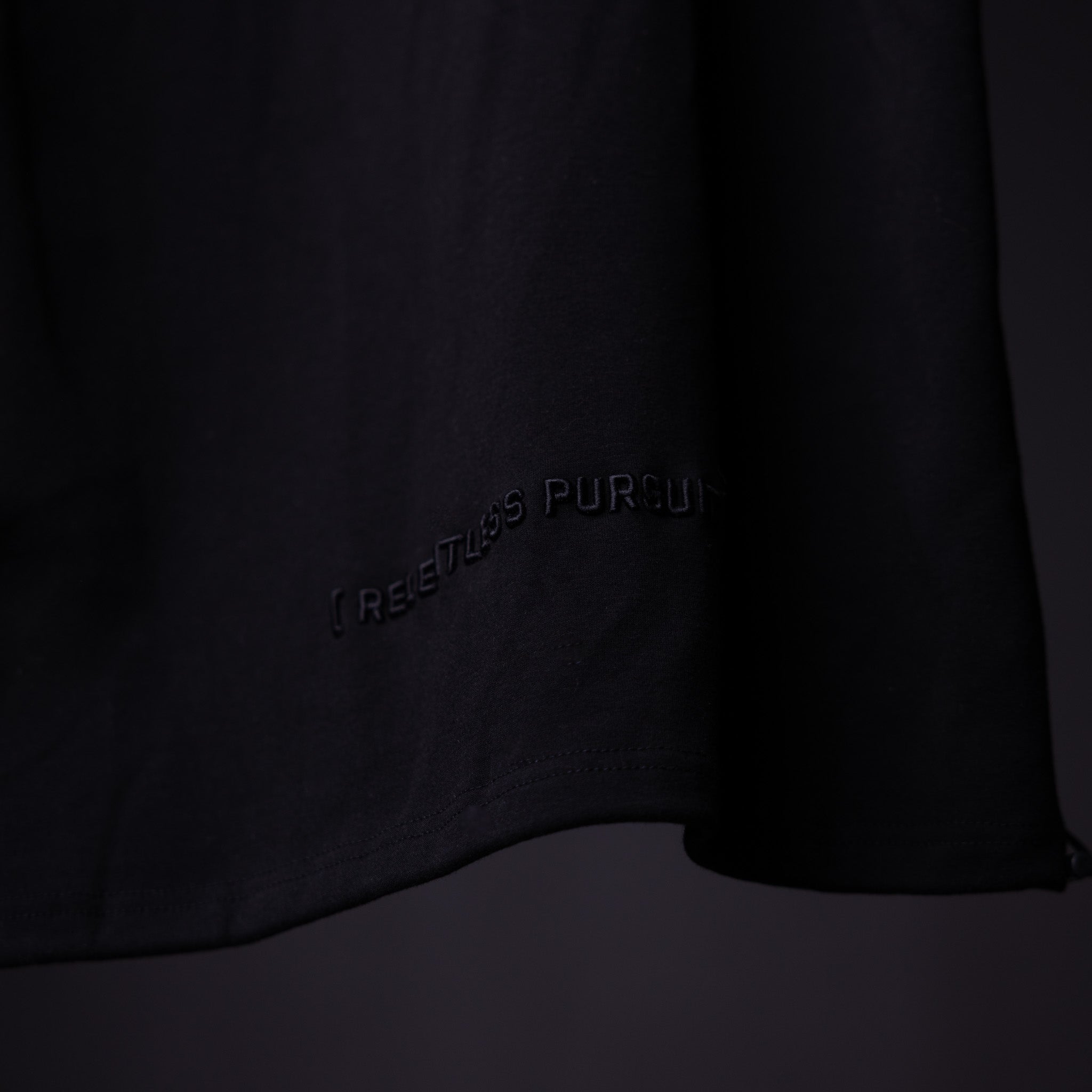 WN'20 Oversized Cinch Tee in black, detail shot of fabric and branding