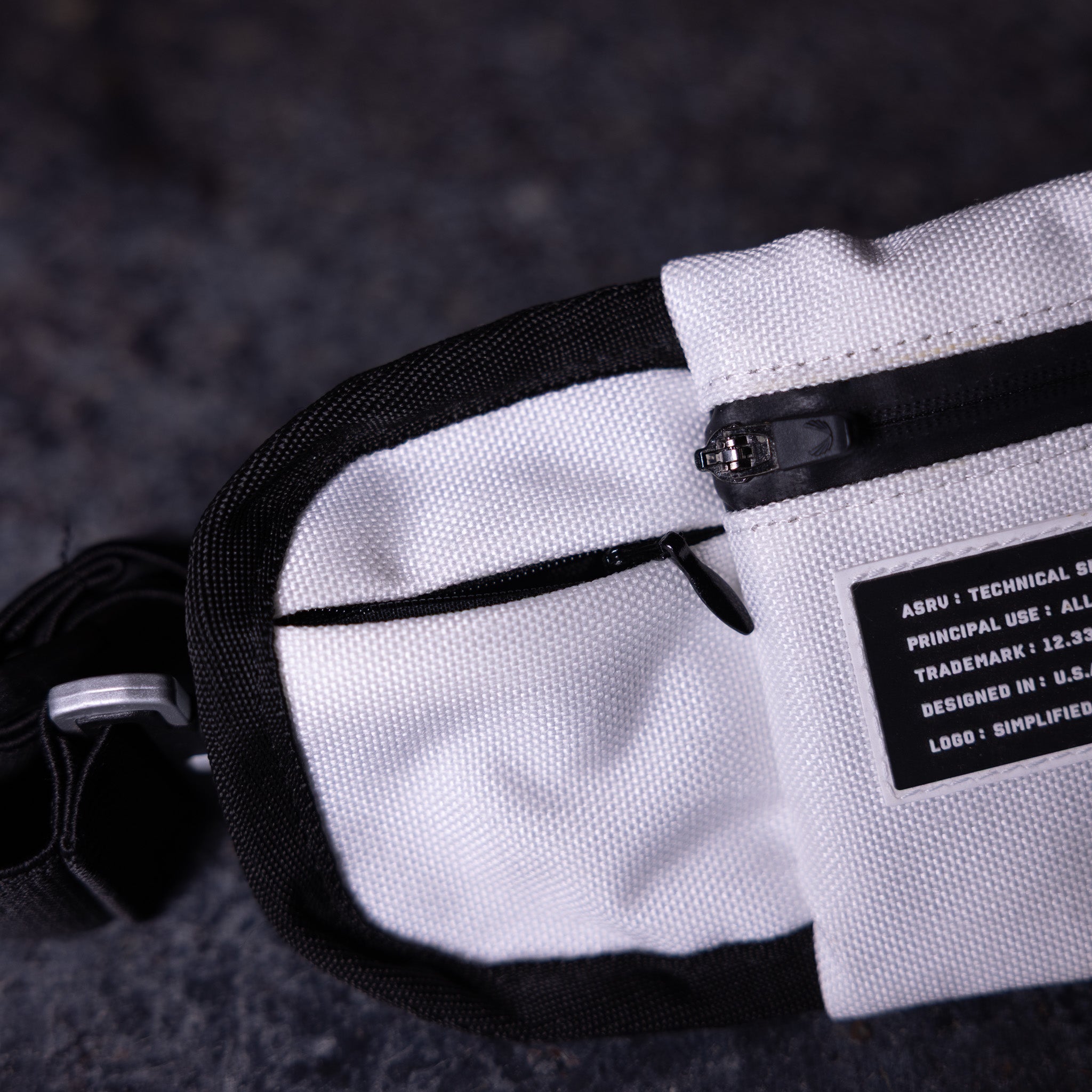 WN'18 Training Belt Pack in white and black, detail shot showing strap and label