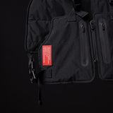 2018 Technical Vest in black, detail shot showing red label and zipper pockets