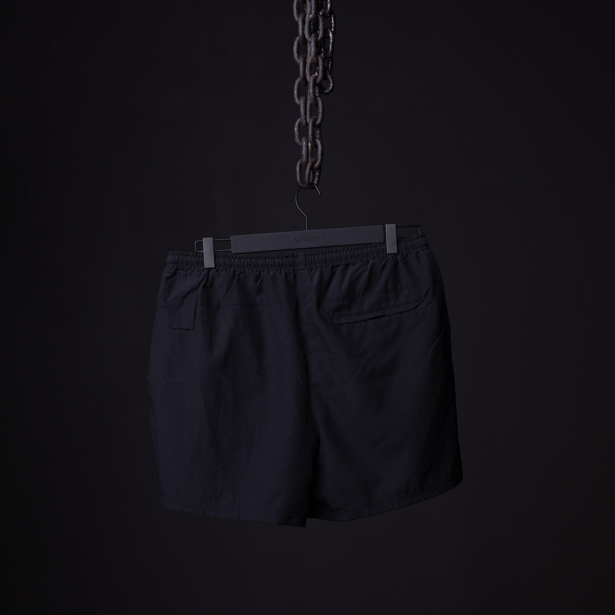 SP'22 Vintage 5" Training Short in black, hung on hanger against dark background