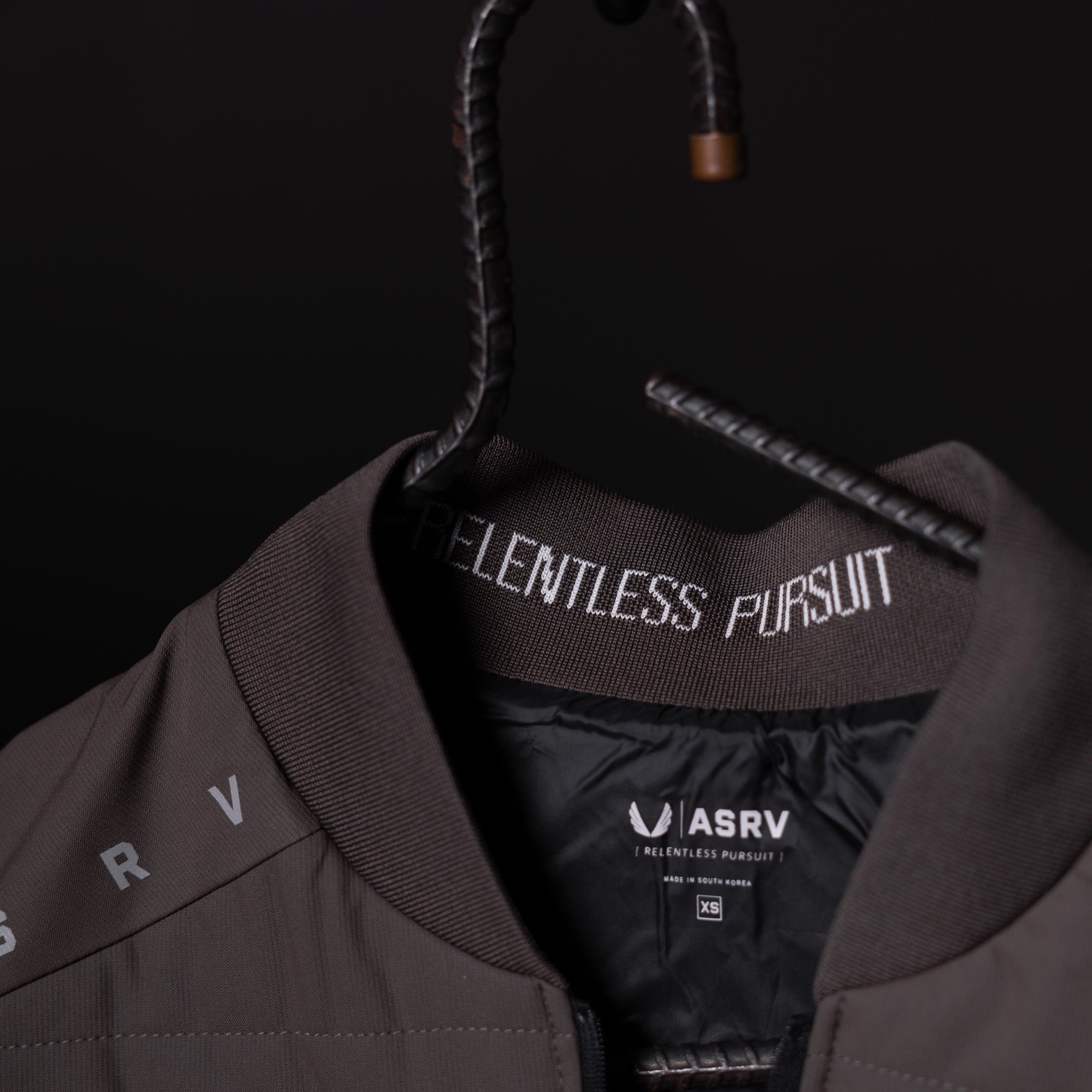 SP'23 Waterproof Run Vest in brown displayed on hanger, showing label detail and front design