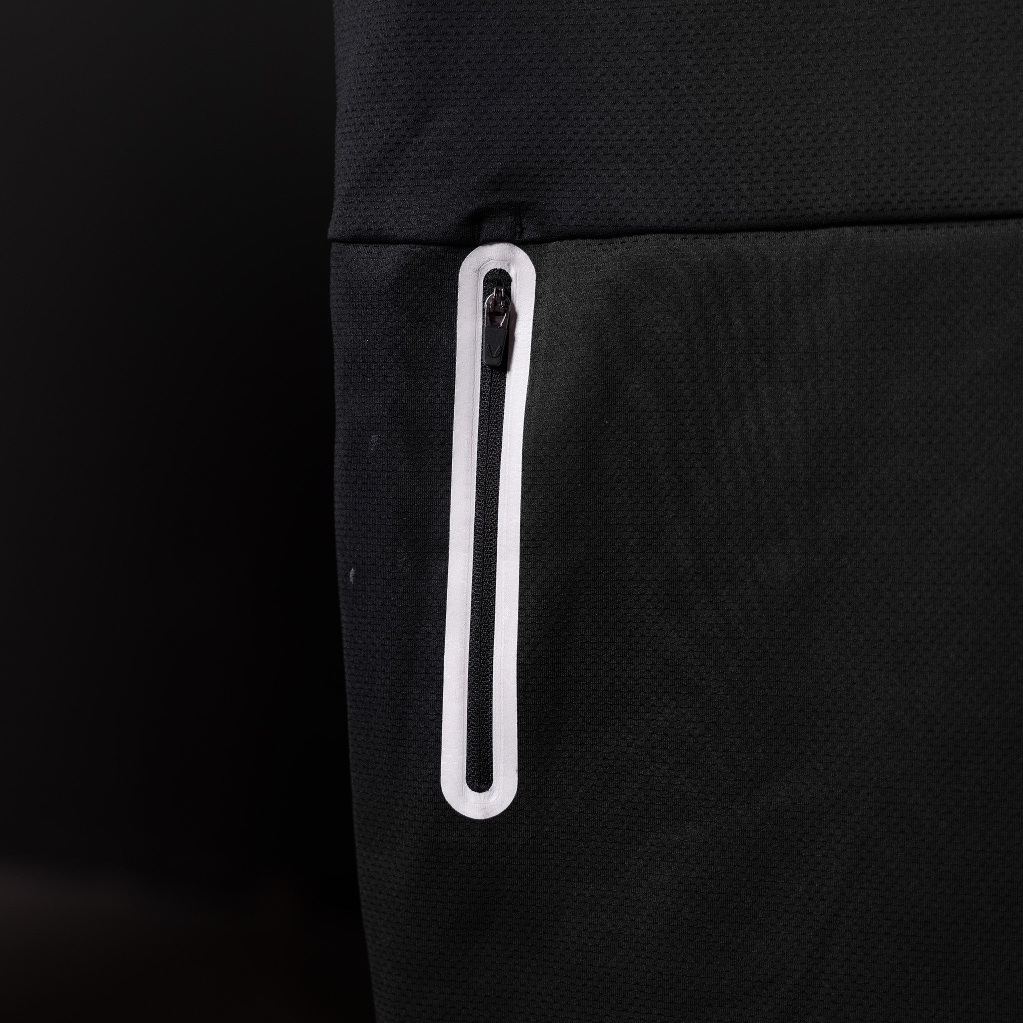 SP'20 Mesh Utility Tank detail shot of white zippered pocket on black fabric