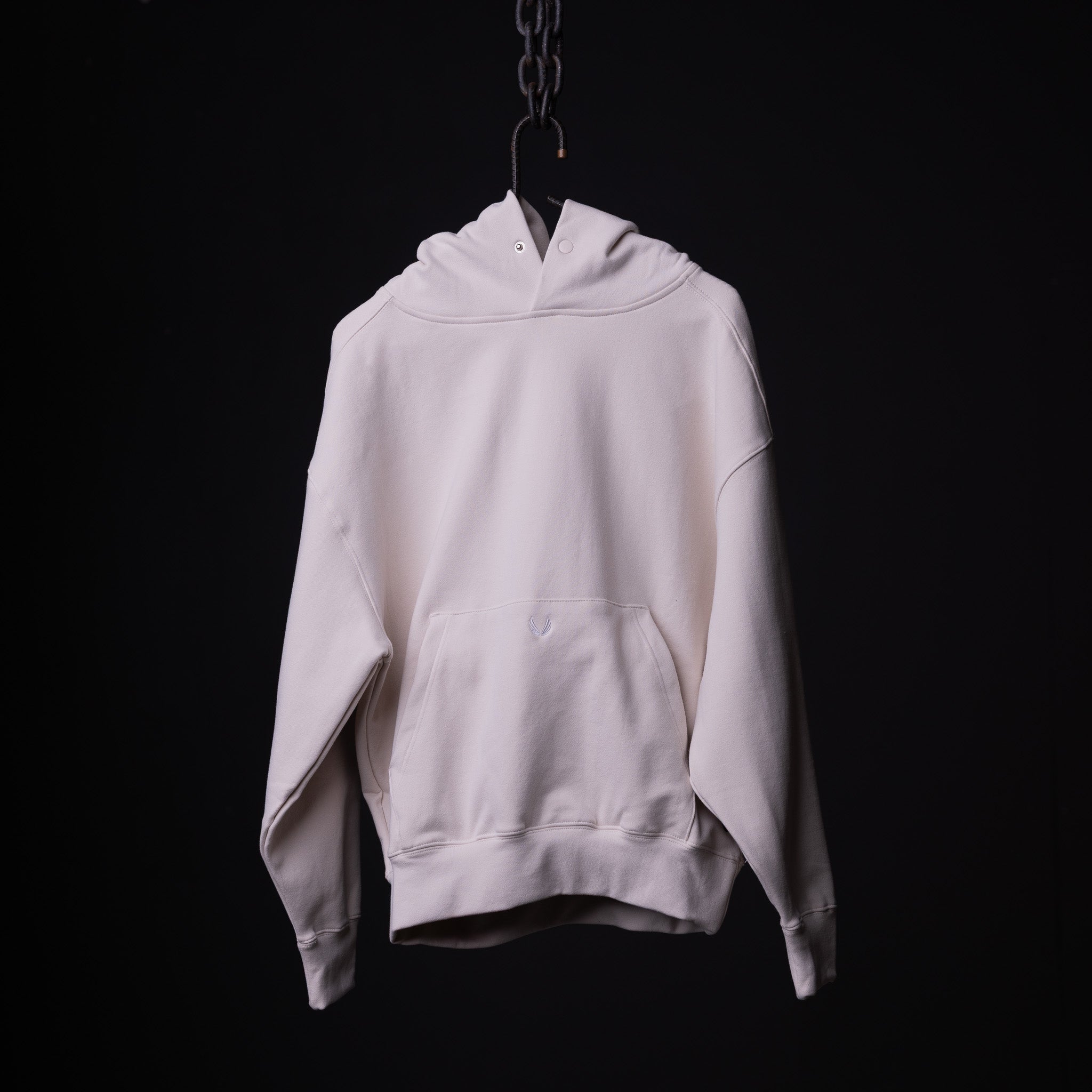 Tech Terry Eagle Hoodie in cream, displayed on hanger against black background