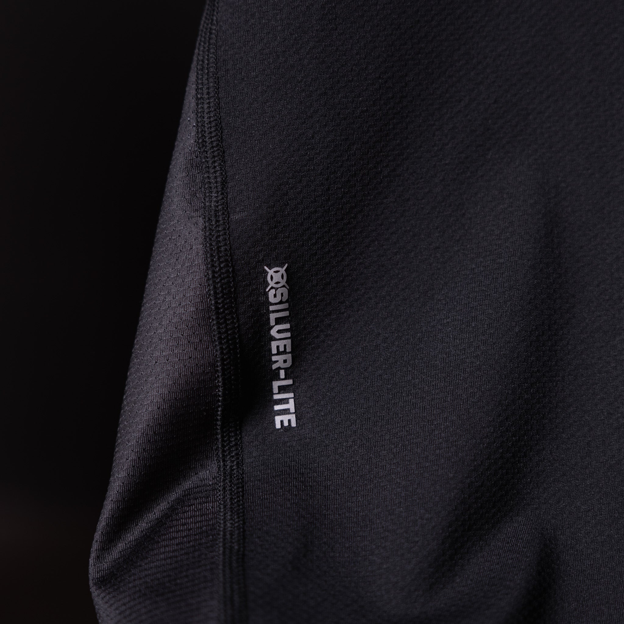 SM'19 Singlet Tank in black, detail shot of side seam and branding label