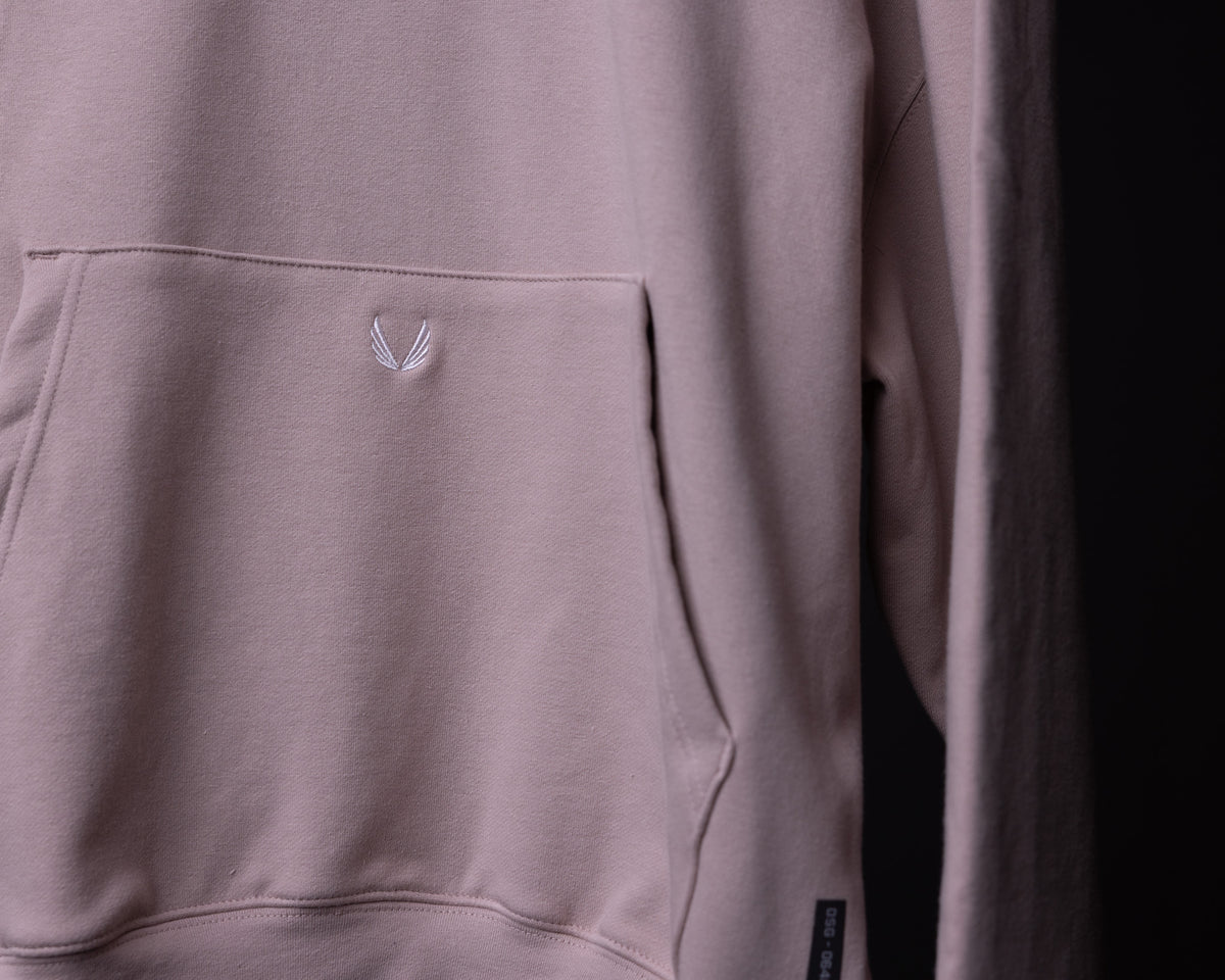 Tech Terry Eagle Hoodie in mauve being worn, detail shot of pocket and embroidered logo