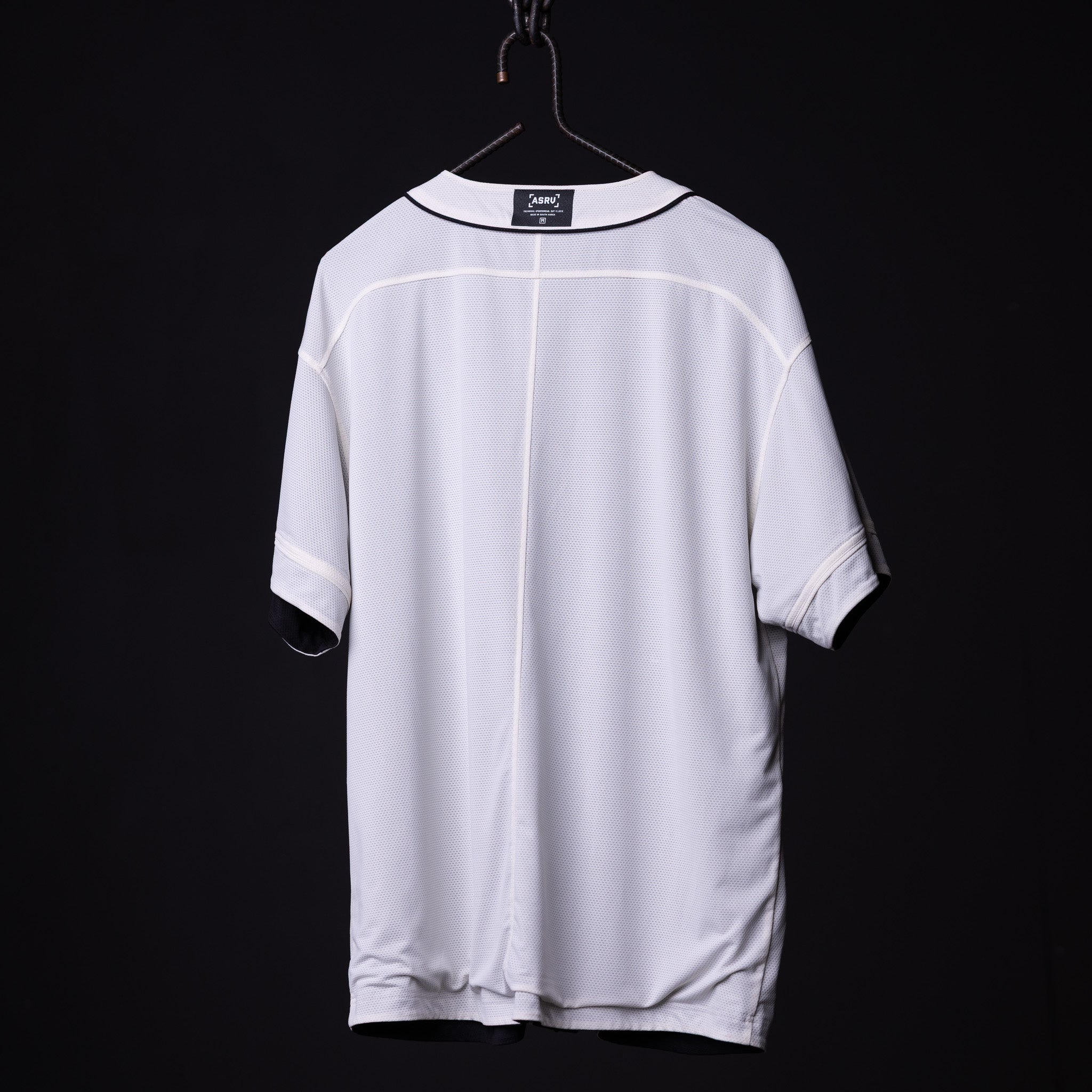 FA'21 Reversible Jersey in white, back view on hanger against black background
