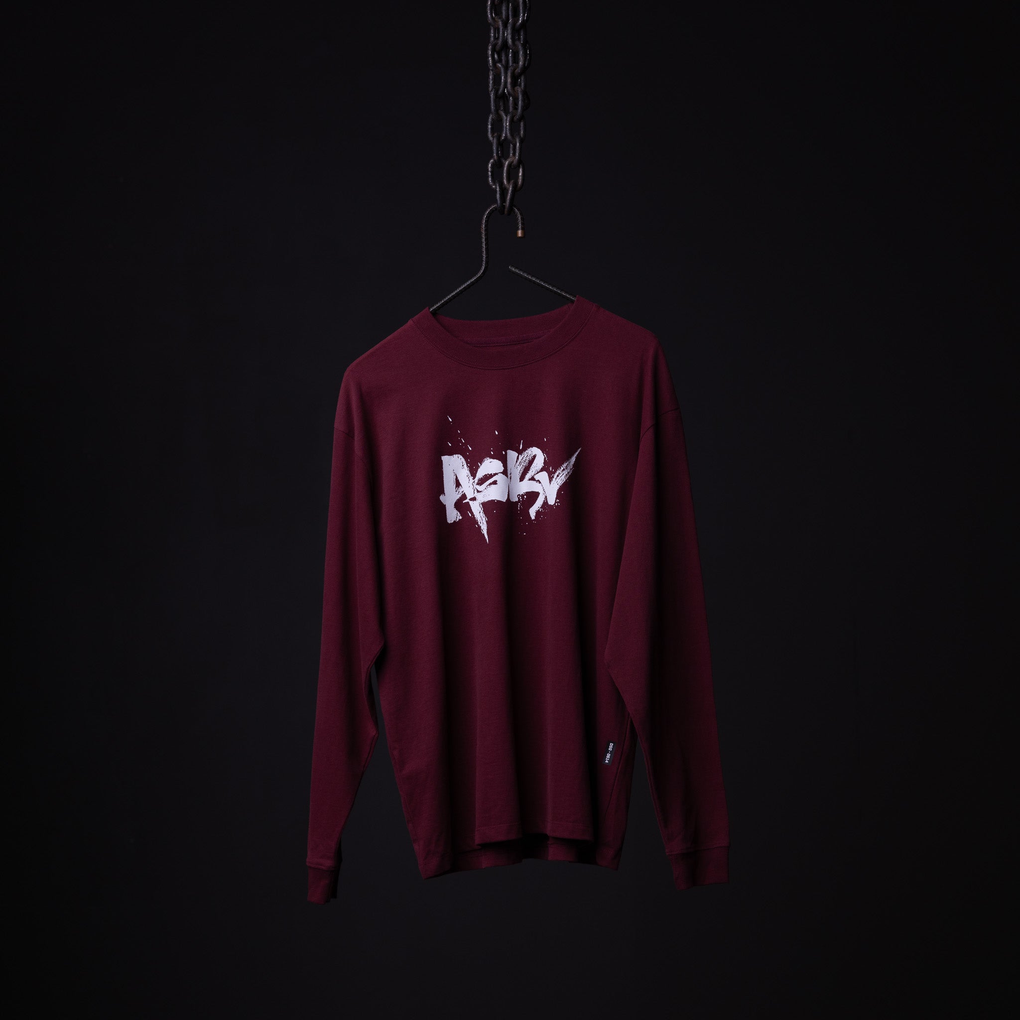 SM'22 Graphic Long Sleeve in maroon with white graphic print, displayed on hanger against dark background