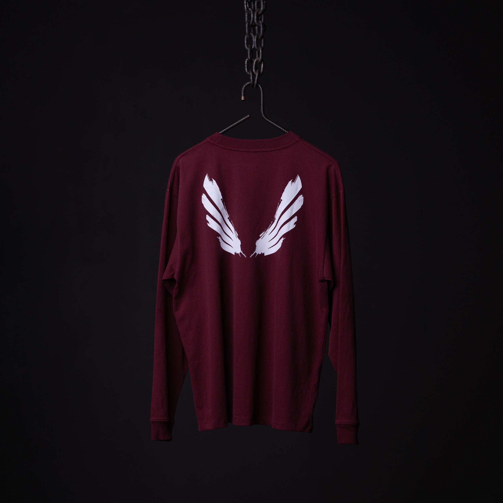 SM'22 Graphic Long Sleeve in maroon with white wing design on back, displayed on hanger